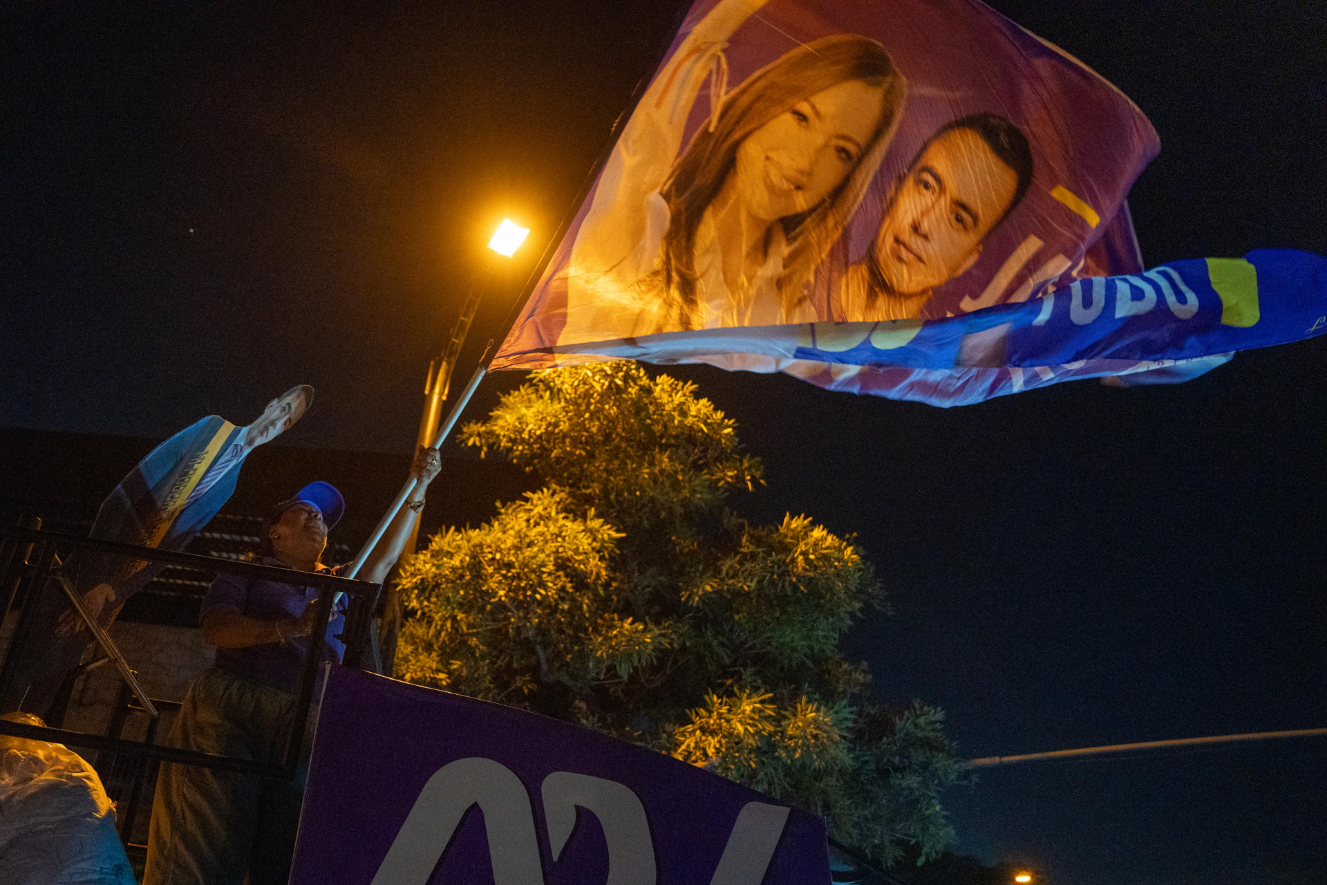 Una persona sostiene una bandera con la imagen de Daniel Noboa este domingo, en Guayaquil (Ecuador). EFE/ Mauricio Torres