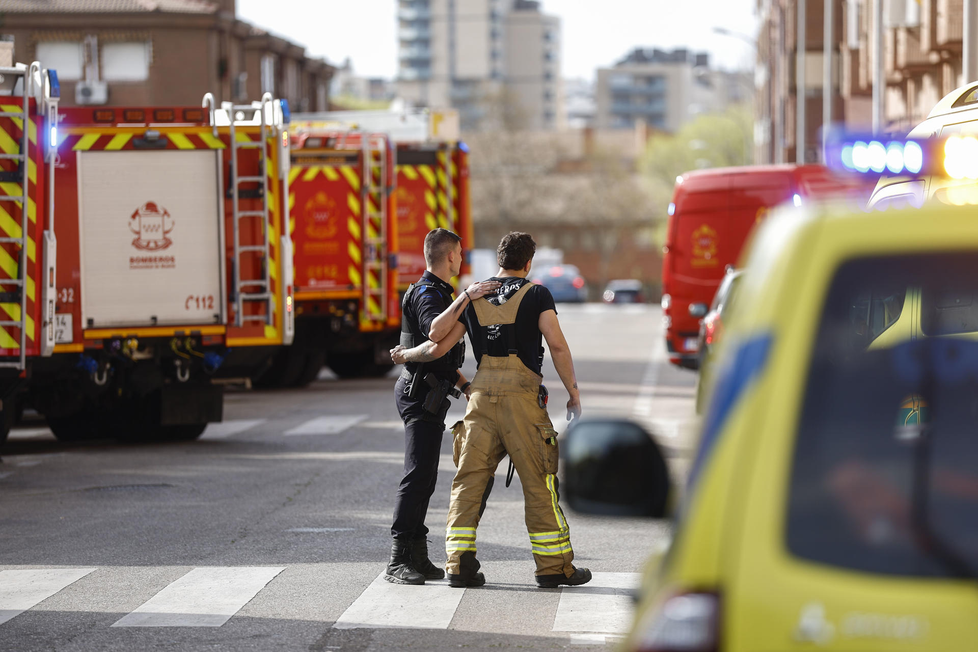 Agentes de la policía acompañan a un bombero en las inmediaciones del garaje incendiado. EFE/ Rodrigo Jimenez