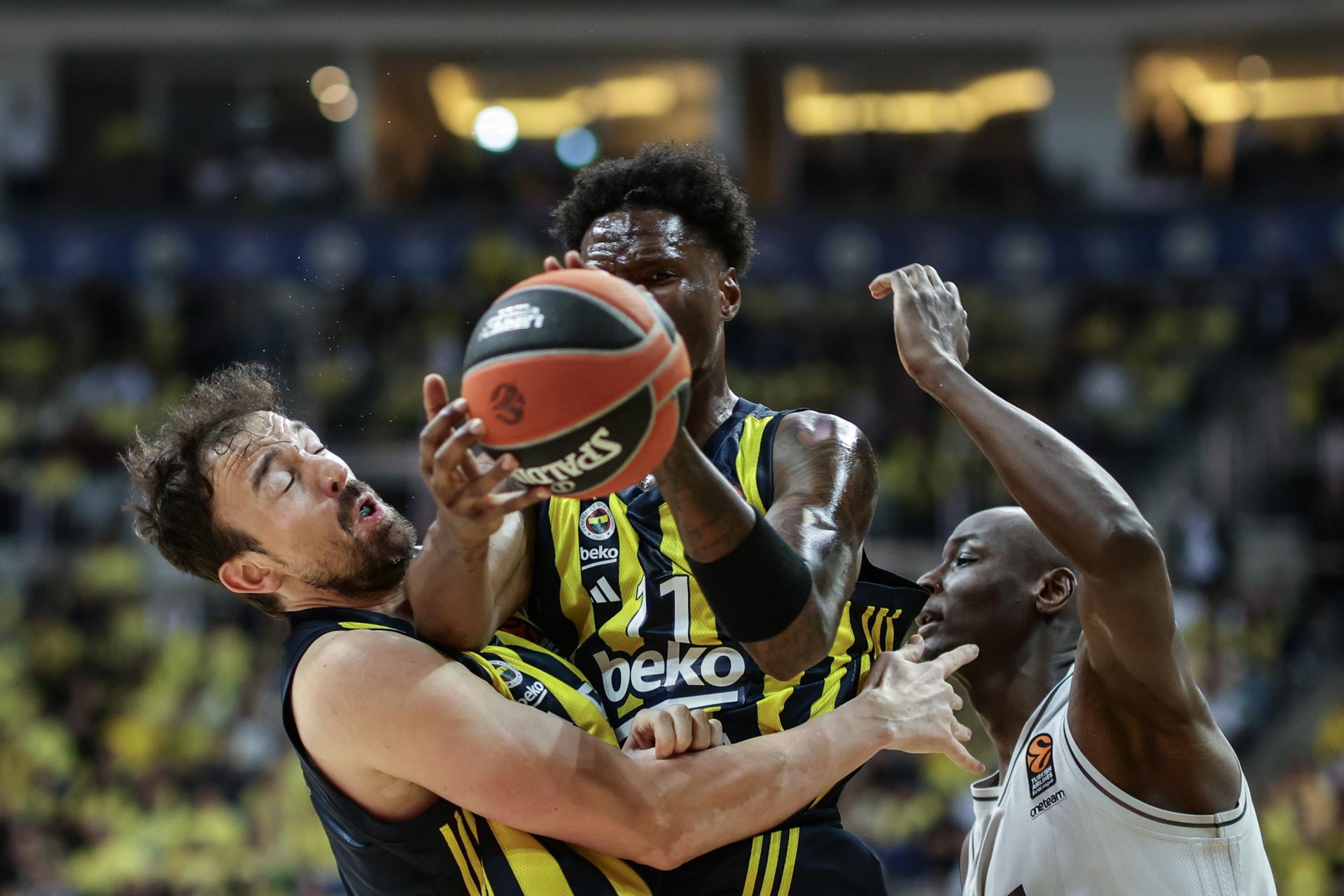 Sertac Sanli (i) y Dyshawn Pierre (c), del Fenerbahce, luchan por un balón ante Bandja Sy (d), del París, en partido de los cuartos de final de la Euroliga de baloncesto. EFE/EPA/ERDEM SAHIN