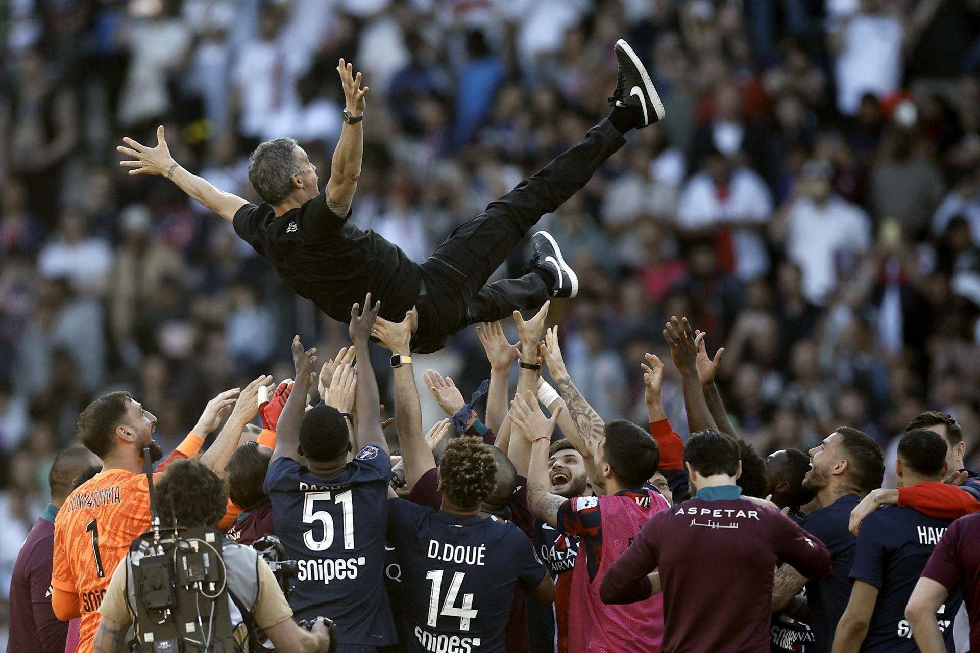 Luis Enrique, manteado por sus jugadores tras certificar el título de la liga francesa. EFE/EPA/YOAN VALAT