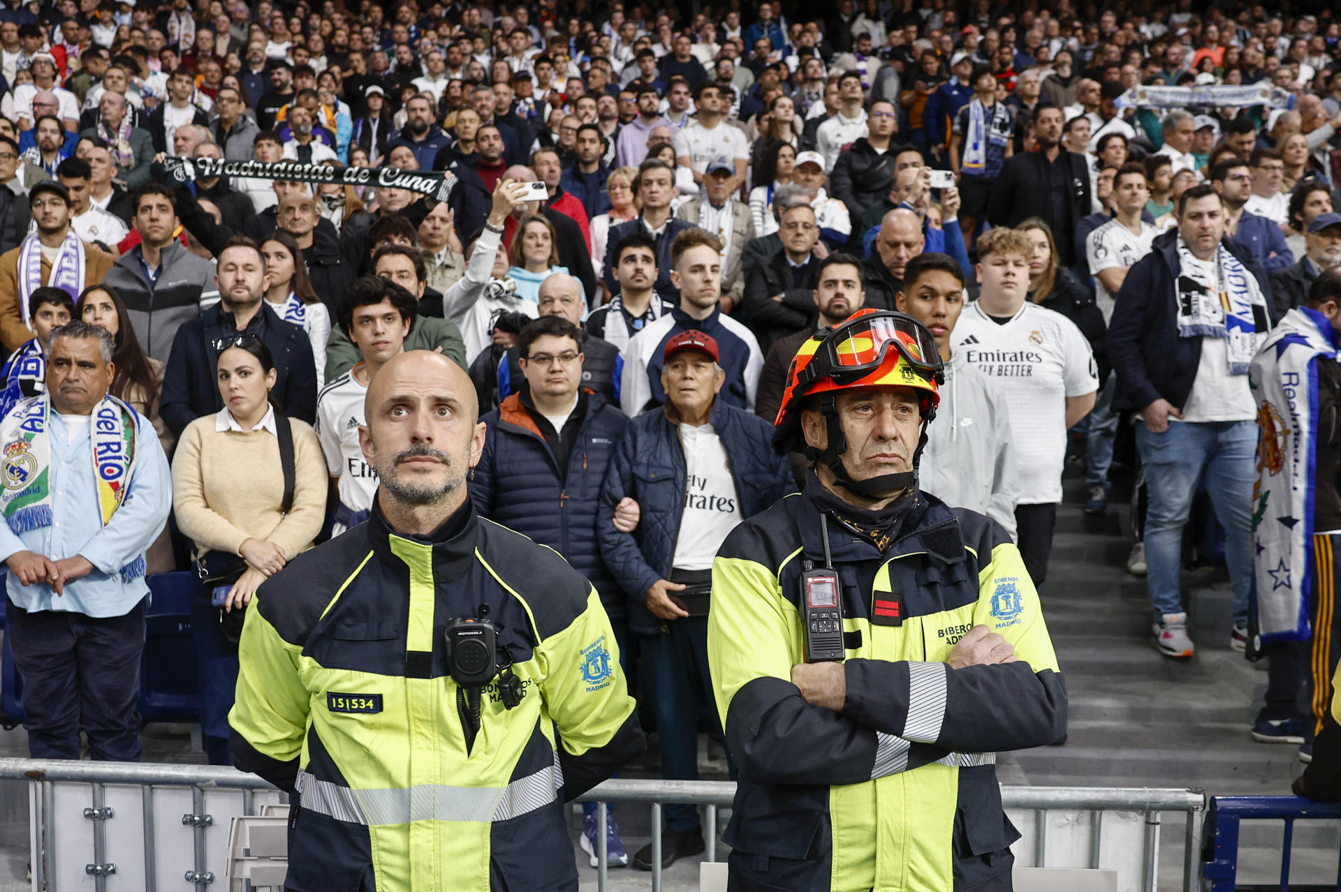 Dos bomberos durante el minuto de silencio por el reciente fallecimiento de dos compañeros de profesión en Alcorcón antes del partido de LaLiga entre el Real Madrid y el Valencia disputado este sábado en el estadio Santiago Bernabéu en Madrid. EFE/Sergio Pérez