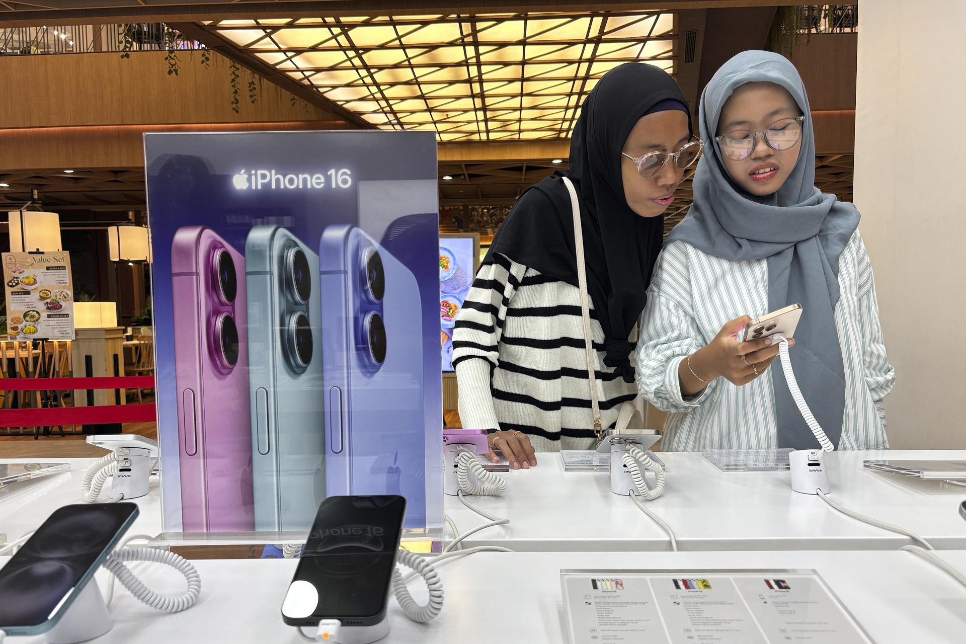 DENPASAR (Indonesia), 11/04/2025.- Customers inspect Apple iPhone 16s at a mall in Denpasar, Bali, Indonesia, 11 April 2025. The iPhone 16 Series officially went on sale in Indonesia on 11 April 2025, after an agreement was reached between the Indonesian Industry Ministry and Apple regarding investment plans in Indonesia. EFE/EPA/MADE NAGI