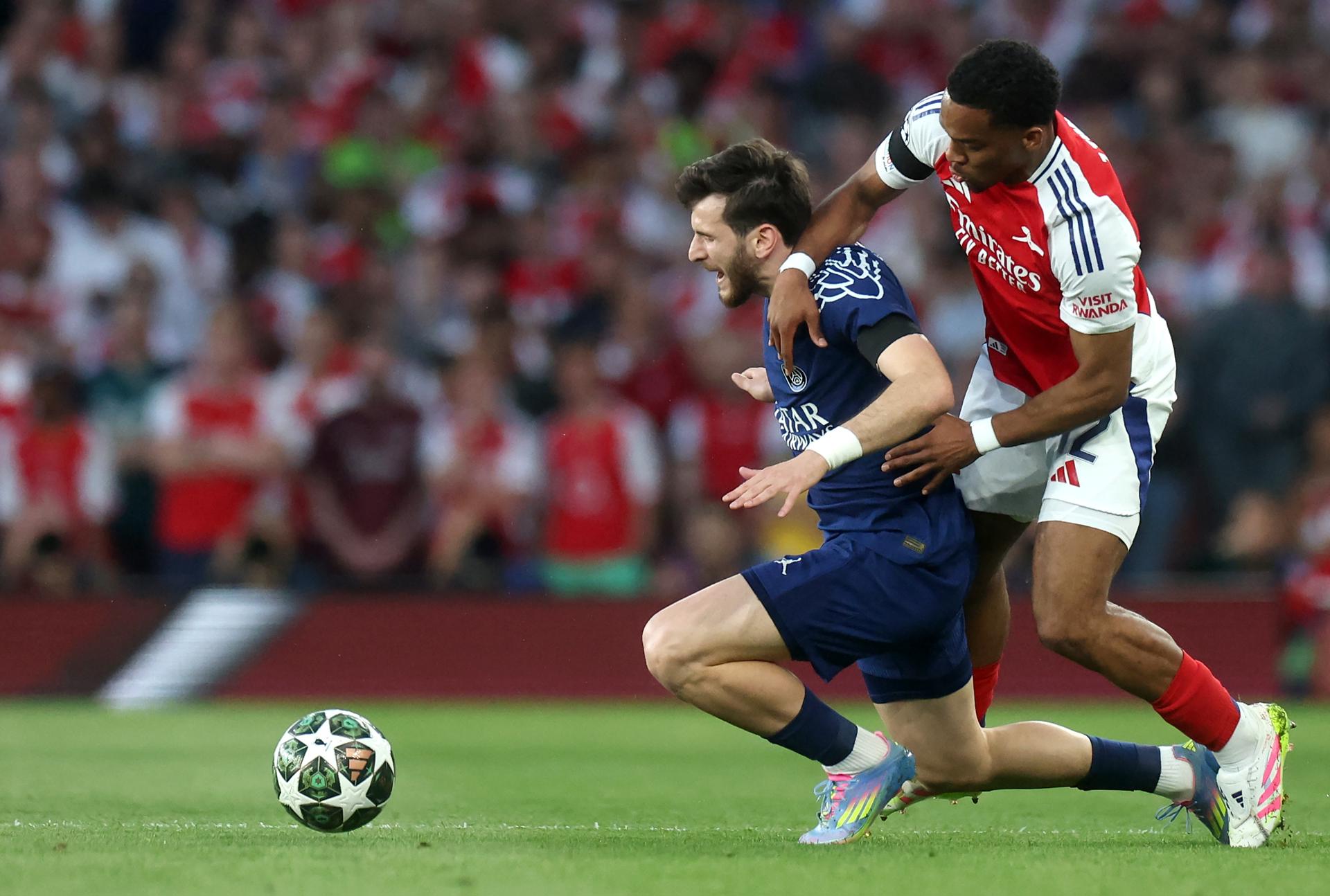 Jurrien Timber (d), del Arsenal, defiende el ataque de Khvicha Kvaratskhelia durante la ida de semifinales de la UEFA Champions League en el Emirates Stadium de Londres, Reino Unido. EFE/EPA/NEIL HALL