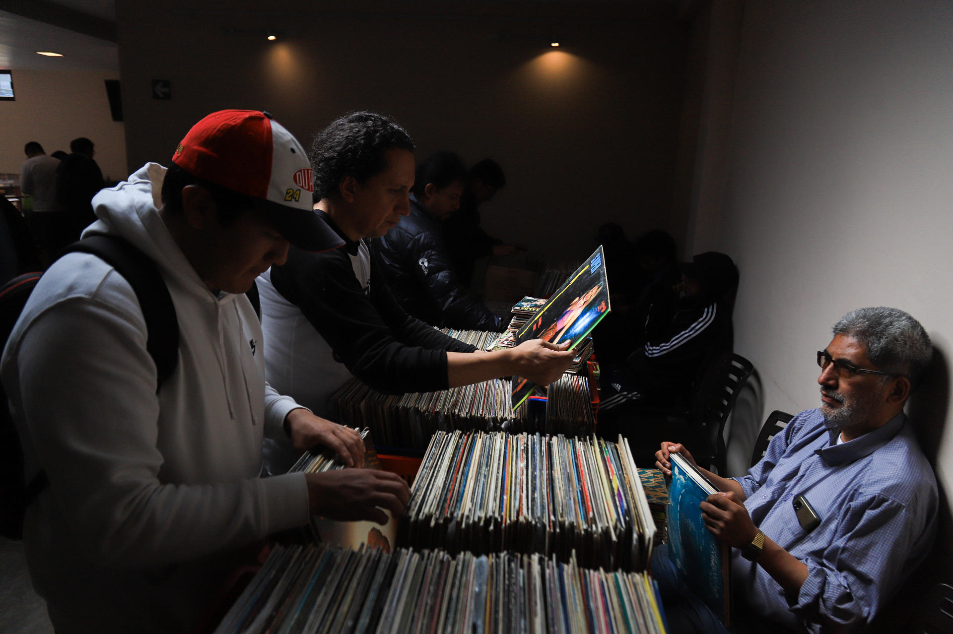 Personas buscan discos de vinilo en una feria este sábado, en La Paz (Bolivia). EFE/ Gabriel Márquez.
