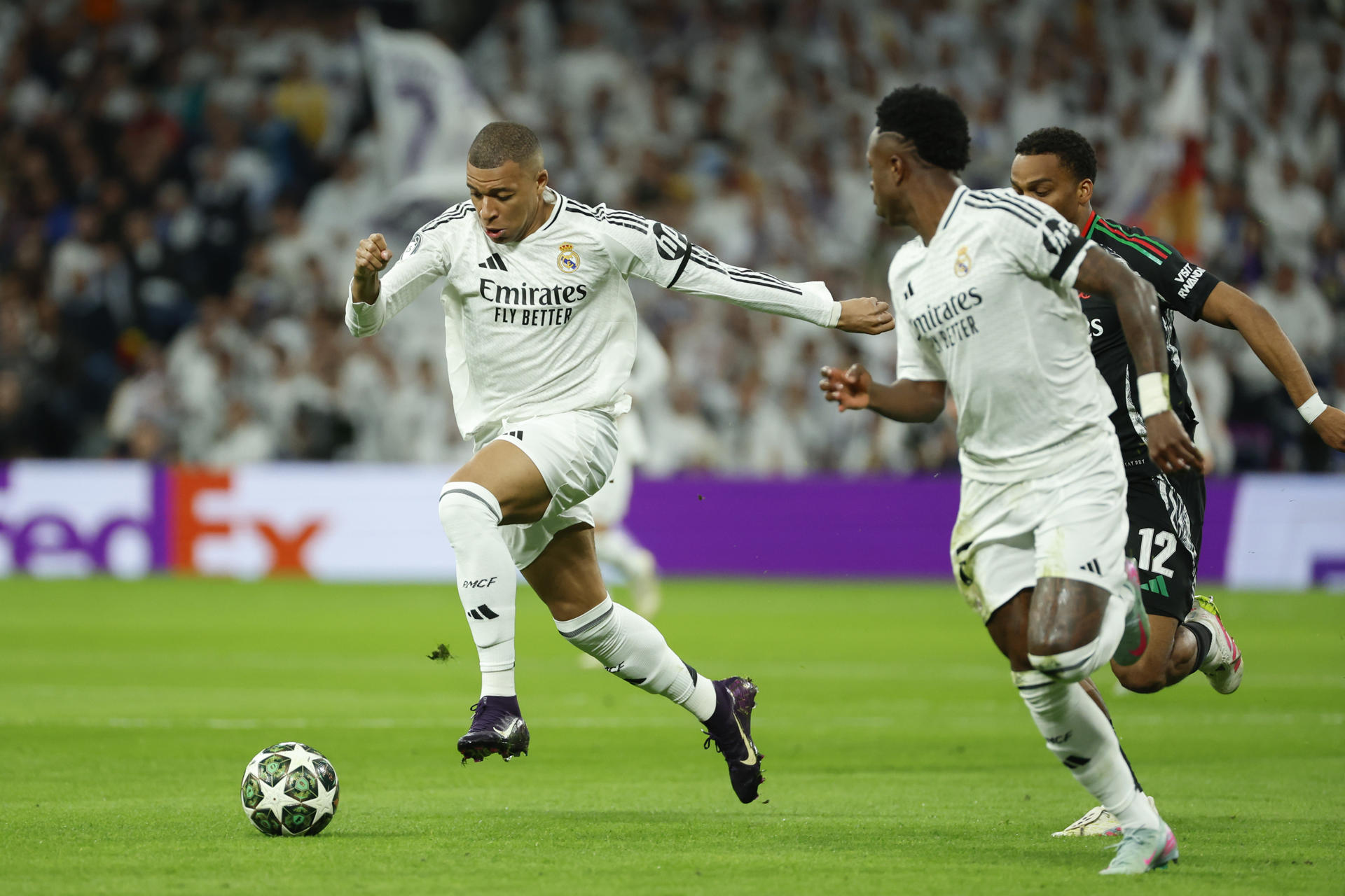 El delantero del Real Madrid Kylian Mbappé (i) se escapa con el balón secundado por Vinicius (d) durante el partido de vuelta de cuartos de final de la Liga de Campeones ante el Arsenal. EFE/Mariscal