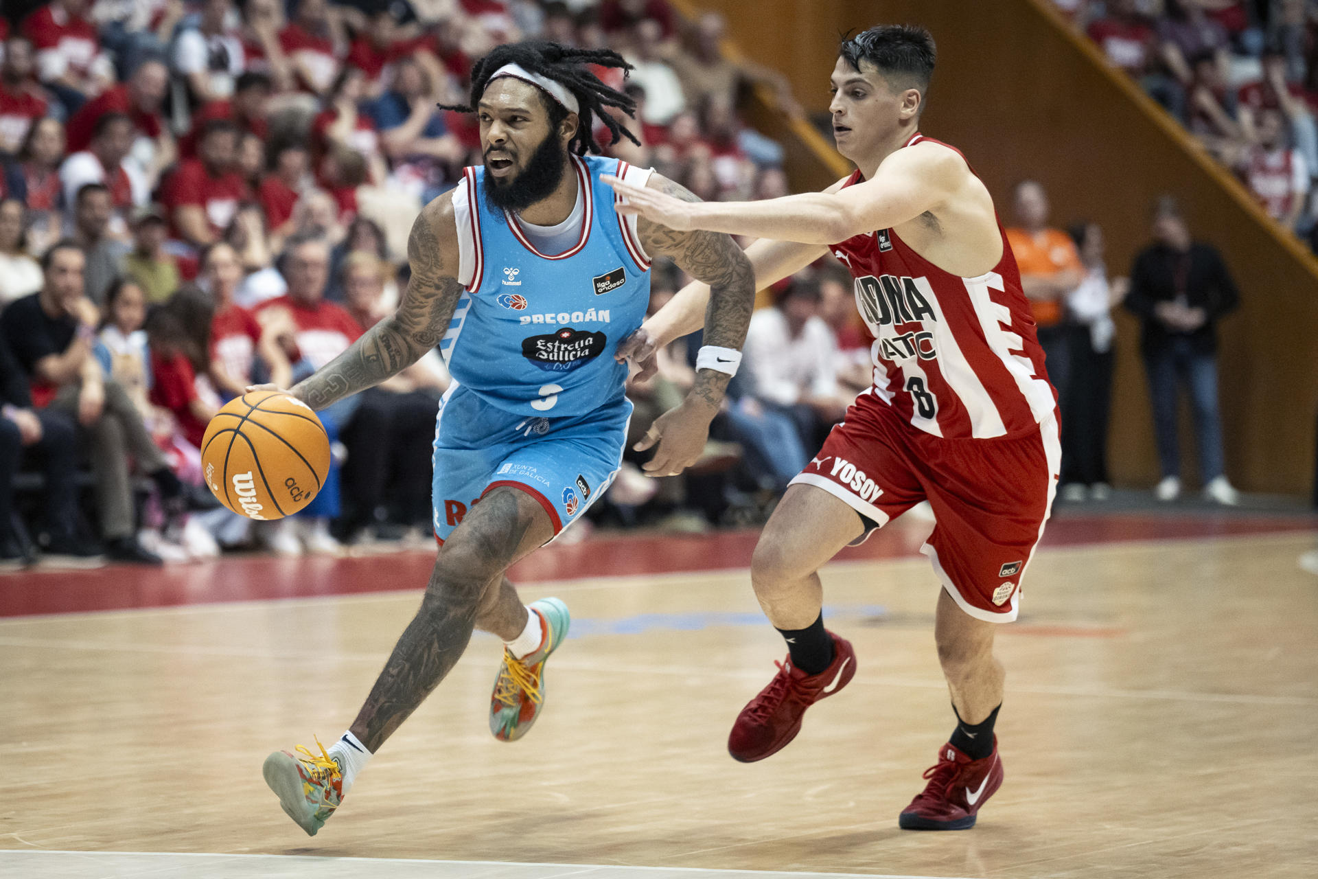 El base del Breogán Devone Grant (i) bota el balón ante el base del Girona Guillem Ferrando (d) durante el encuentro de Liga Endesa entre Bàsquet Girona y CB Breogán celebrado en el Pabellón Municipal Girona-Fontajau. EFE/ David Borrat