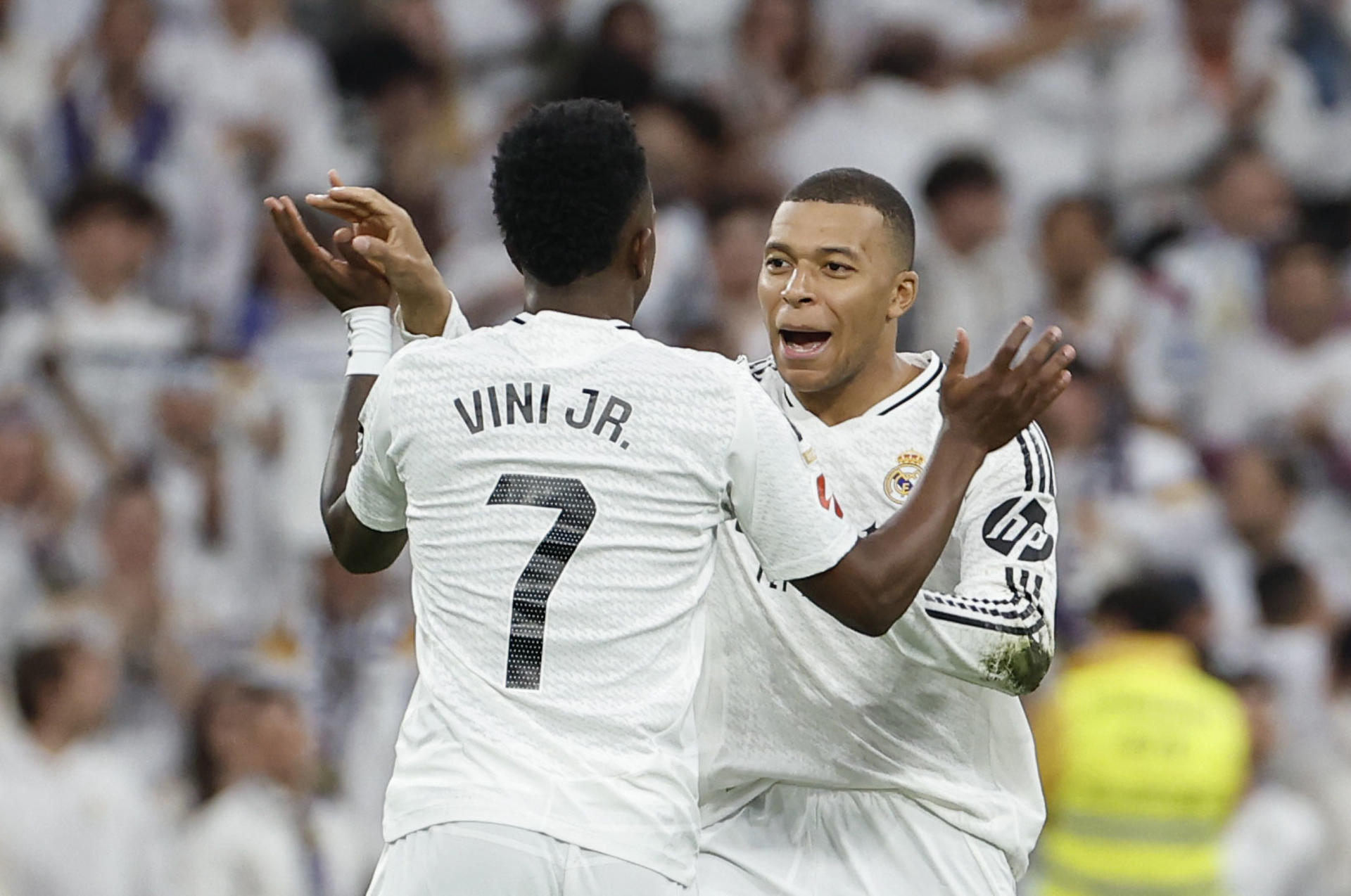 El delantero del Real Madrid Vinicius (izda) celebra un gol con Kylian Mbappé en el estadio Santiago Bernabéu en Madrid. EFE/Chema Moya