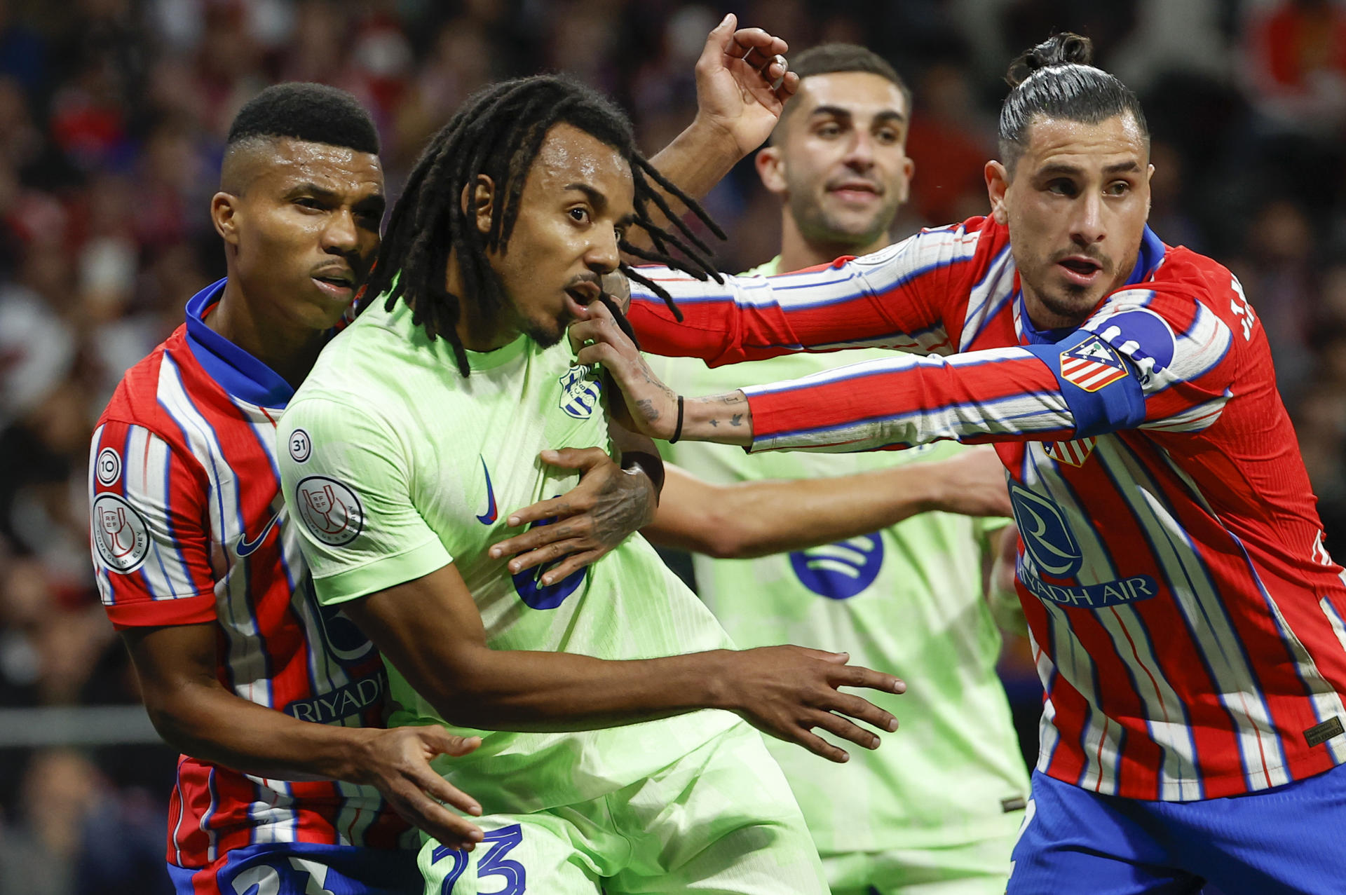 El defensa uruguayo del Atlético de Madrid José María Giménez (d) y el defensa francés del Barcelona Jules Koundé (2i) durante el encuentro correspondiente a la vuelta de las semifinales de la Copa del Rey que disputan hoy miércoles Atlético de Madrid y FC Barcelona en el estadio Metropolitano, en Madrid. EFE / Chema Moya