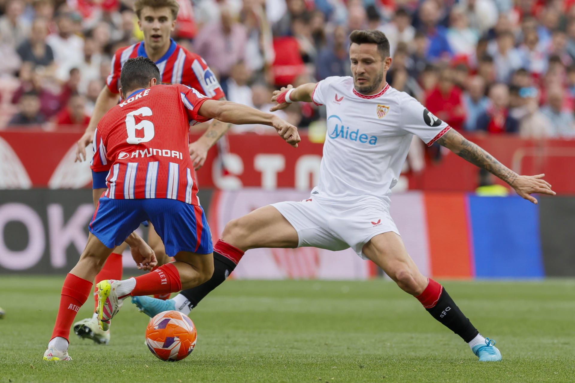 El centrocampista del Atlético de Madrid Koke (i) pelea un balón con el centrocampista del Sevilla Saúl Ñíguez durante el partido de LaLiga entre el Sevilla y el Atlético de Madrid, este domingo en el estadio Sánchez Pizjuán. EFE/ José Manuel Vidal