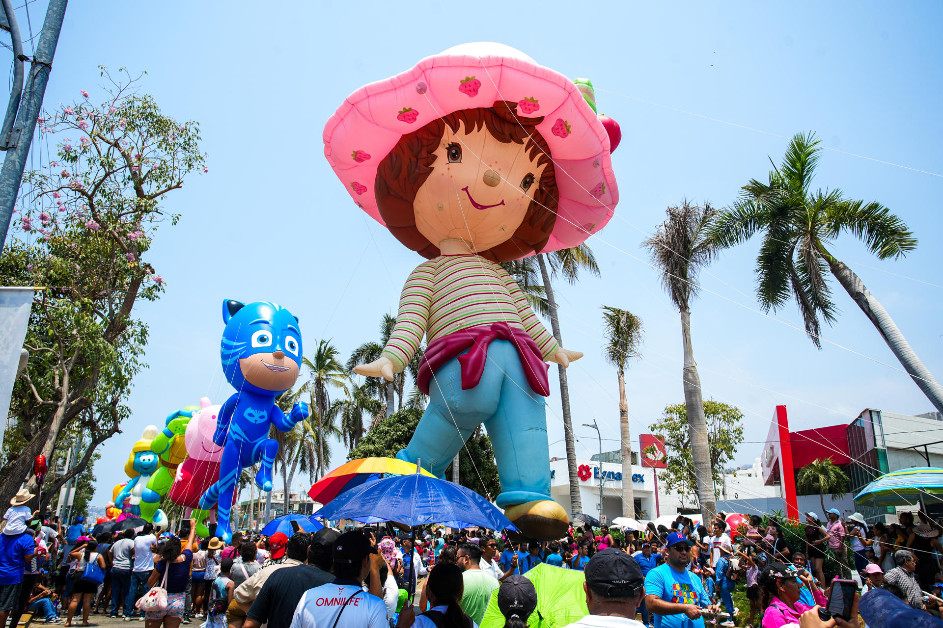 Personas participan en un desfile de figuras de globos gigantes este sábado, en Acapulco (México). EFE/ David Guzmán