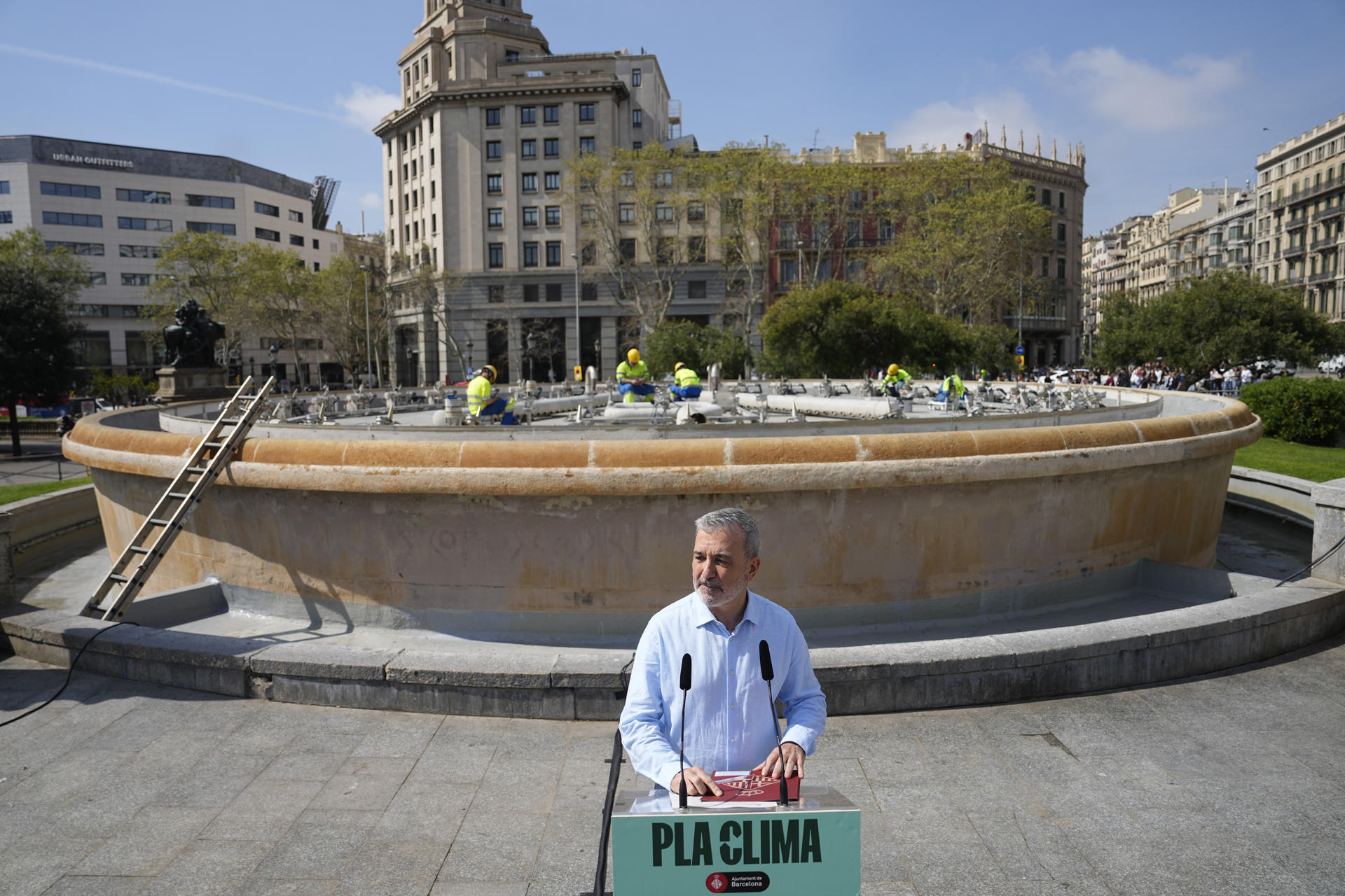 Barcelona ha iniciado un proceso progresivo, que durará varios meses, para recuperar sus fuentes ornamentales, apagadas durante la sequía, y en concreto en la Font Màgica de Montjuïc volverá a brotar agua el próximo septiembre, para las fiestas de La Mercè.En la imagen, el alcalde de Barcelona, Jaume Collboni anuncia las medidas mientras unos operarios realizan tareas de reparación en las fuentes de Plaza Catalunya.EFE/ Enric Fontcuberta