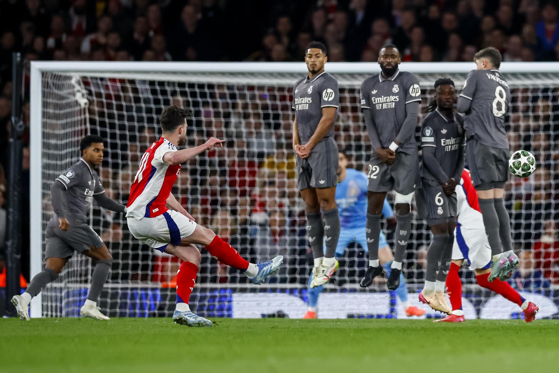 Declan Rice (i) ejecuta un tiro libre para anotar el 1-0 frente al Real Madrid, durante el partido de ida de los cuartos de final de la Liga de Campeones. EFE/EPA/TOLGA AKMEN