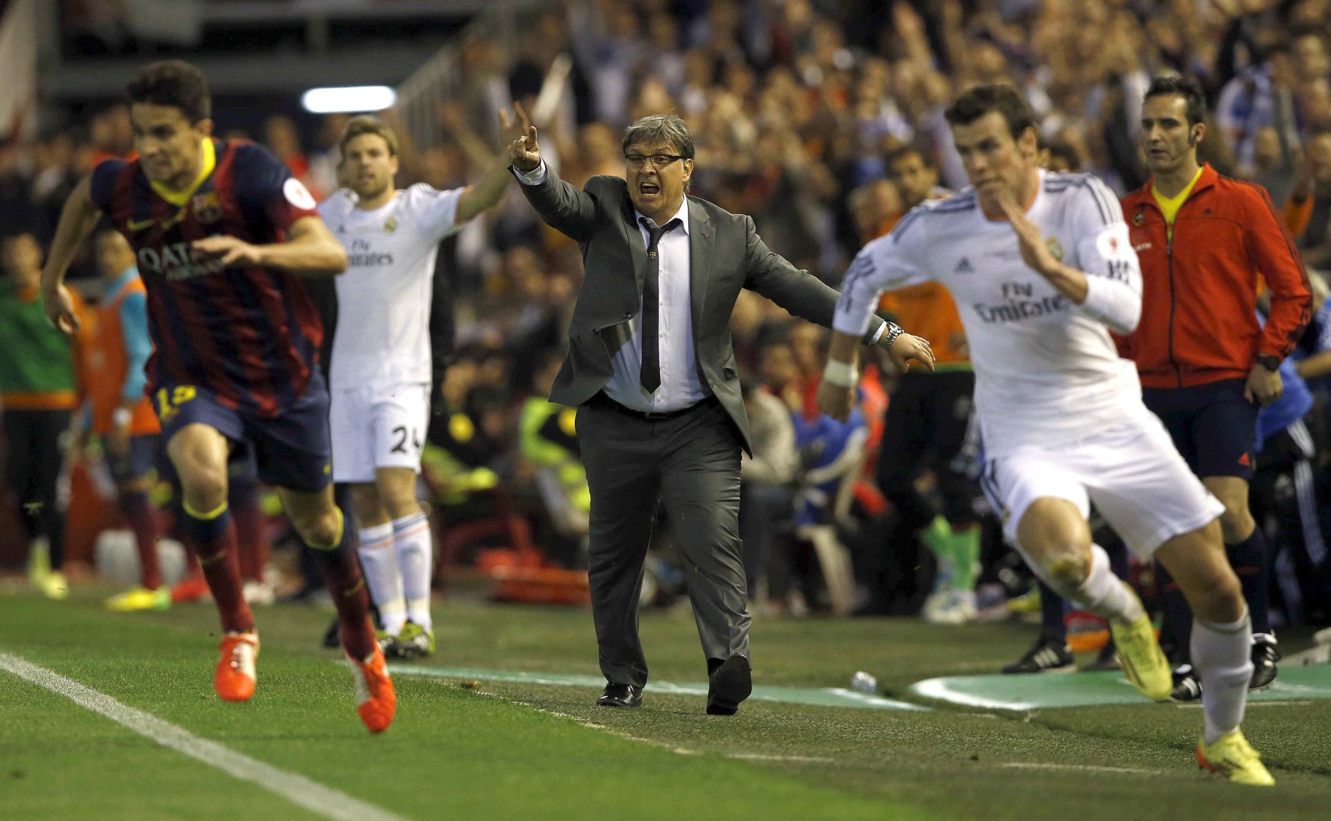 Gareth Bale (d) emprende la carrera frente a Marc Bartra (i), para desesperación del entrenador argentino del FC Barcelona Gerardo Martino (c), en la jugada del segundo gol madridista en la final de la Copa del Rey 2014, la imagen más icónica de la estancia del delantero galés en el Real Madrid. EFE/Alberto Estévez