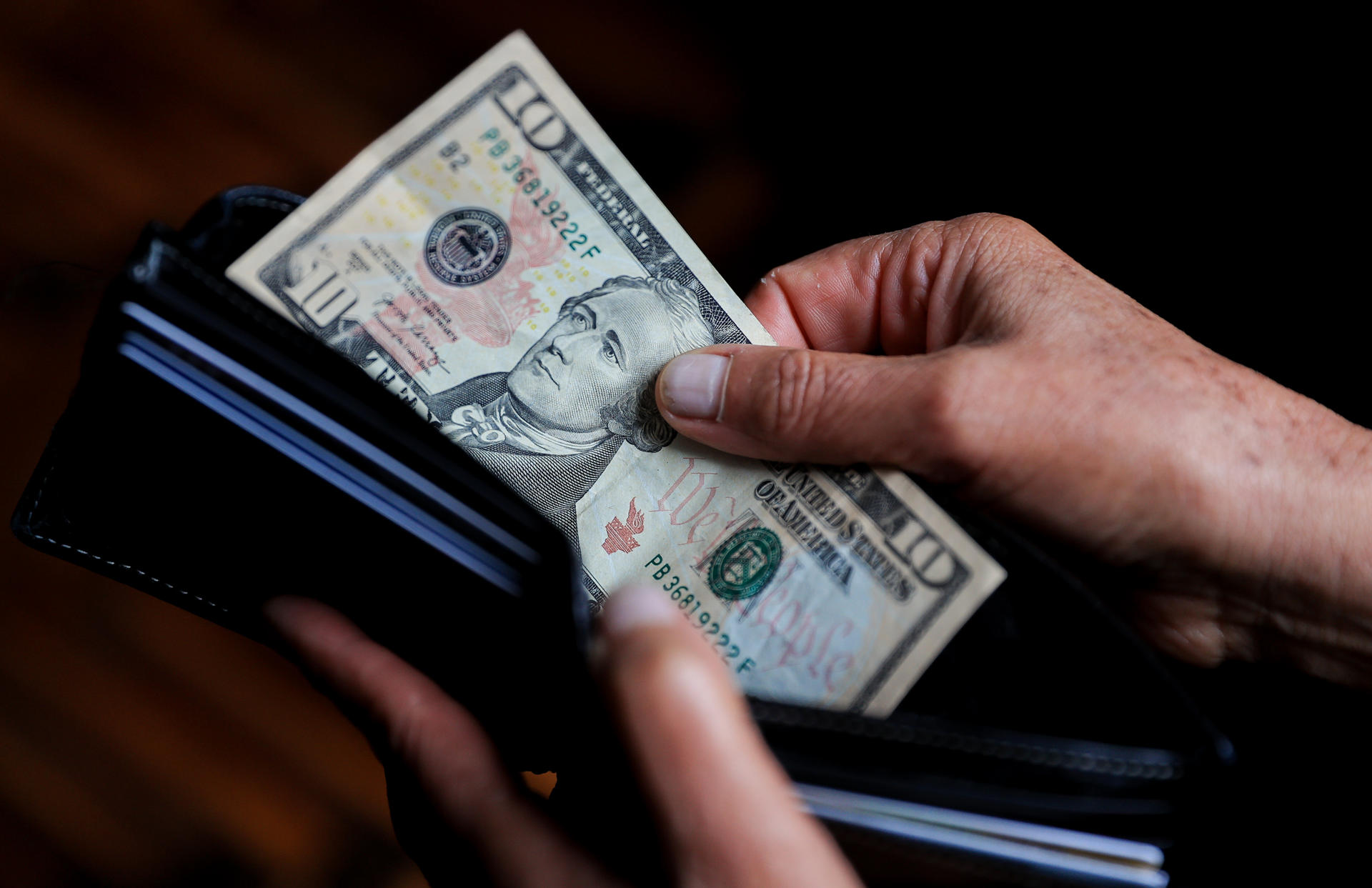 Una persona sostiene un billete de 10 dolares en Quito (Ecuador). EFE/ José Jácome