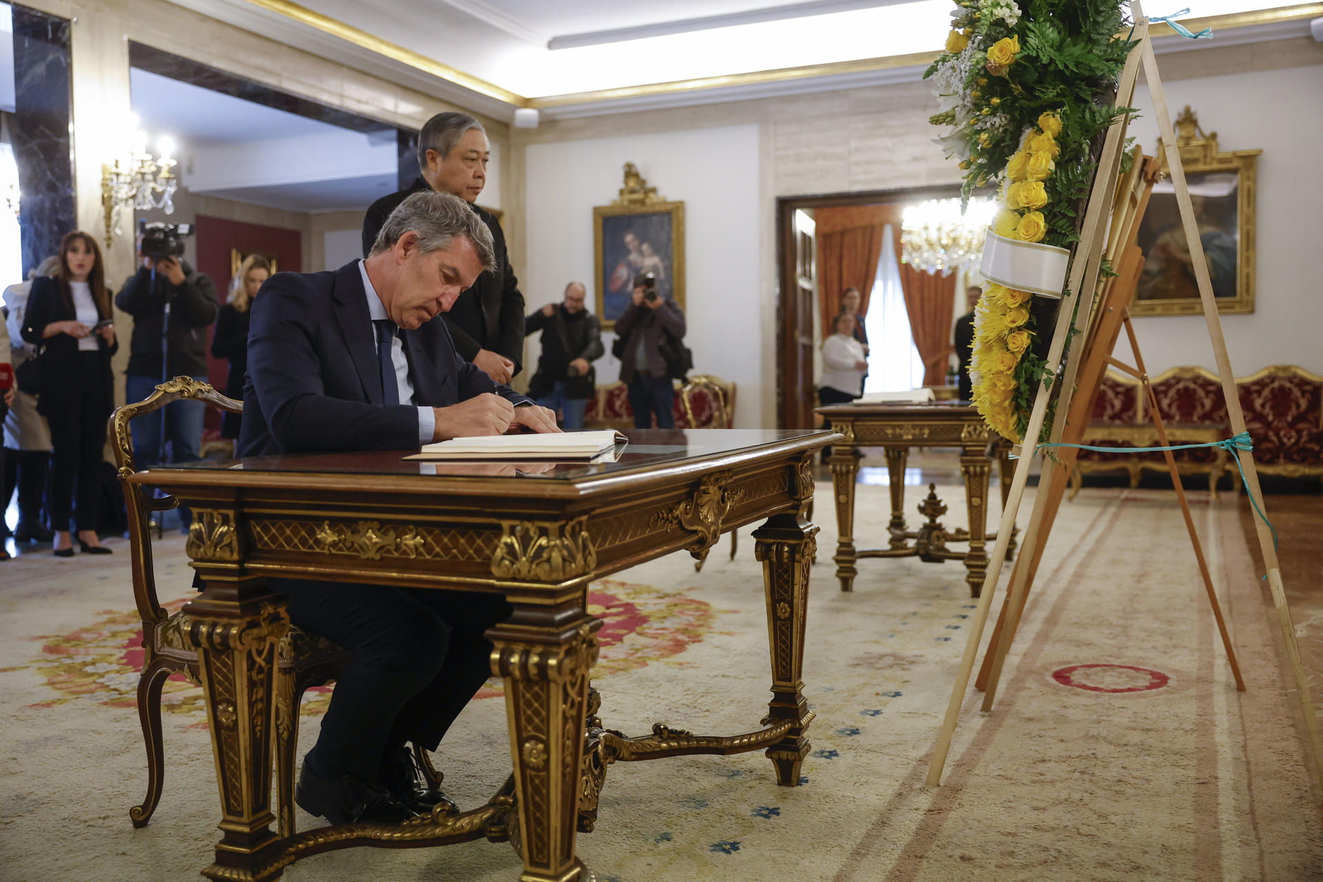 El líder del PP, Alberto Núñez Feijóo, firma en el libro de condolencias abierto este martes en la Nunciatura Apostólica en Madrid por la muerte del papa Francisco, fallecido ayer lunes. Detrás de Feijóo, Bernardito Cleopas Auza, nuncio apostólico en España. EFE/ Juan Carlos Hidalgo