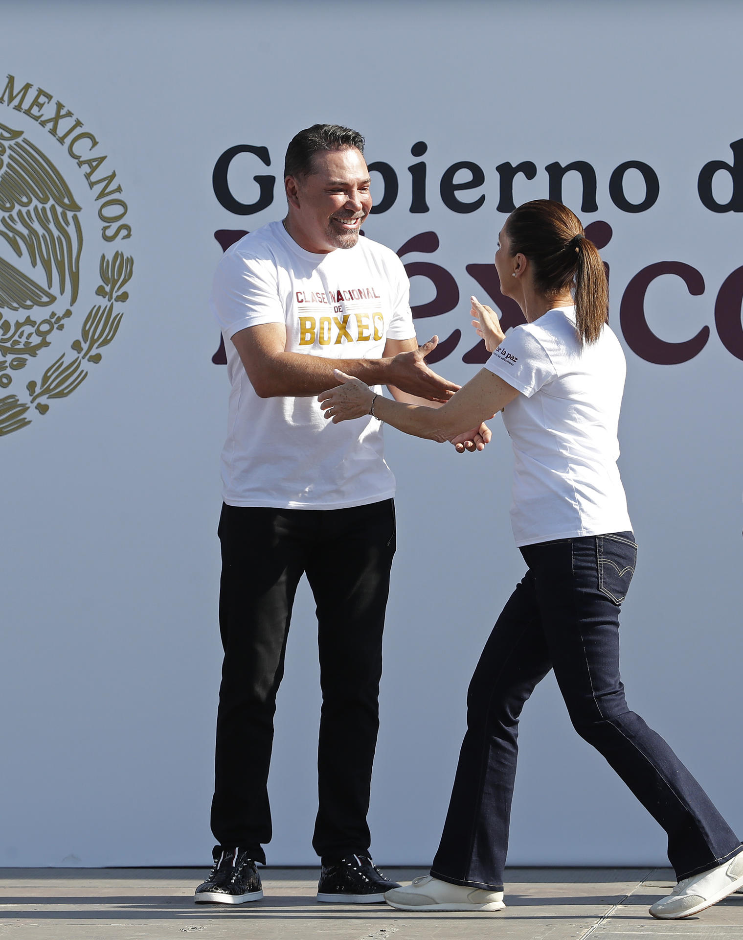 La presidenta de México Claudia Sheinbaum (d), saluda al ex boxeador Óscar de la Hoya (i), en el arranque masivo de una Clase Nacional de Boxeo 2025, impartida este domingo en la plancha del Zócalo, de la Ciudad de México (México). EFE/Mario Guzmán
