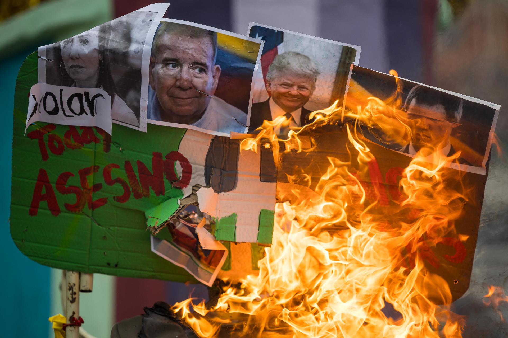 Personas queman un muñeco con fotografías de Nayib Bukele, Maria Corina Machado, Edmundo Gonzalez, Donald Trump, Juan Guaido e Irfaan Ali este domingo, durante la tradicional Quema de Judas, en Caracas (Venezuela). EFE/ Miguel Gutiérrez