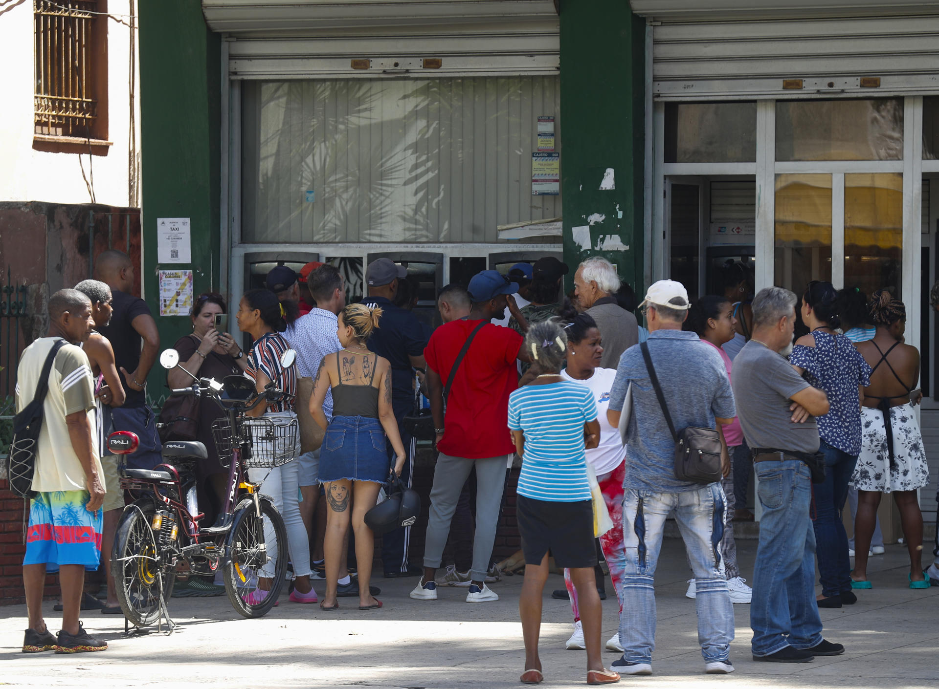 Fotografía de archivo de un grupo de personas al hacer fila frente al cajero automático de un banco en La Habana (Cuba). EFE/Yander Zamora