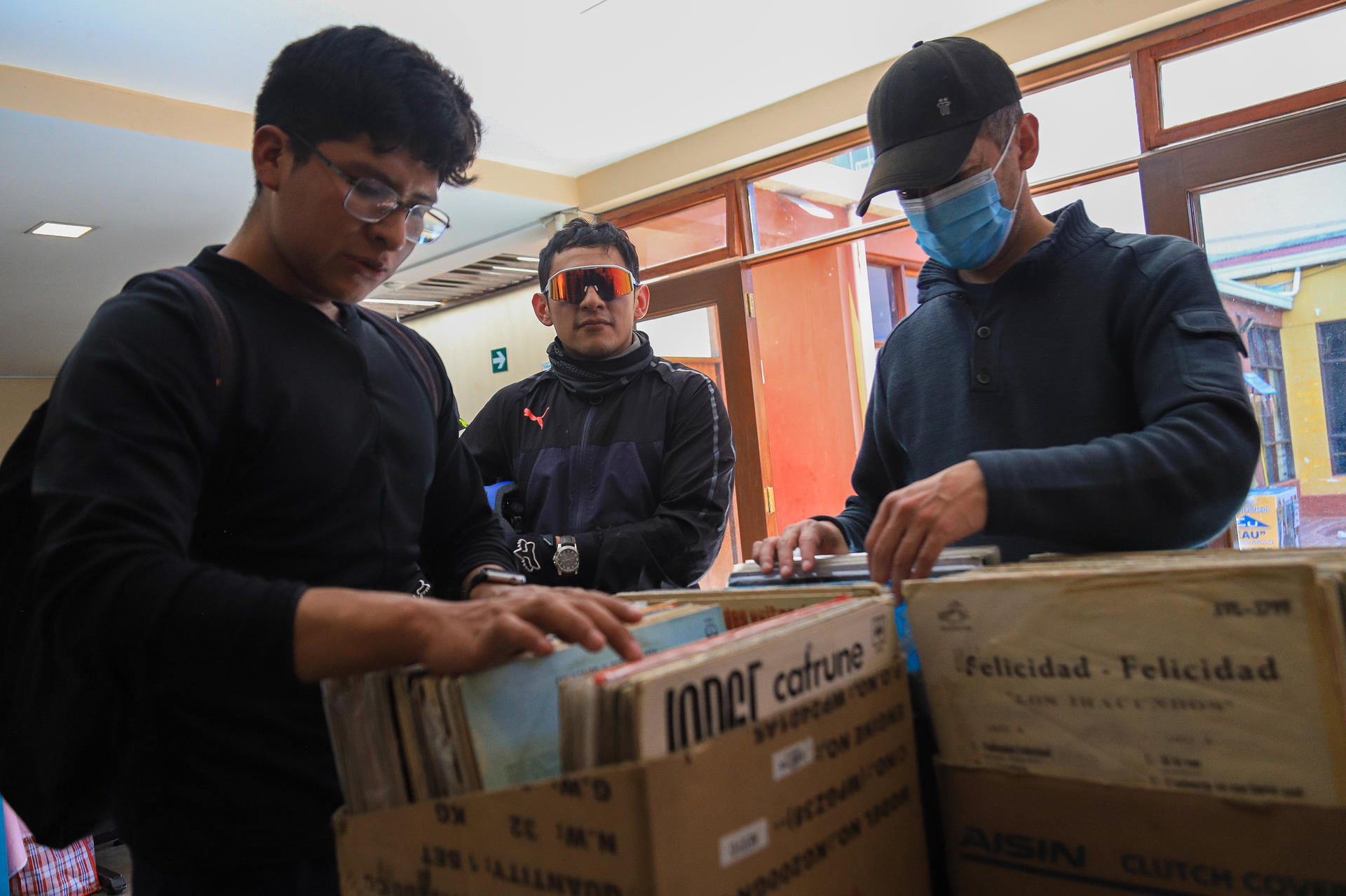 Personas buscan discos de vinilo en una feria este sábado, en La Paz (Bolivia). EFE/ Gabriel Márquez.
