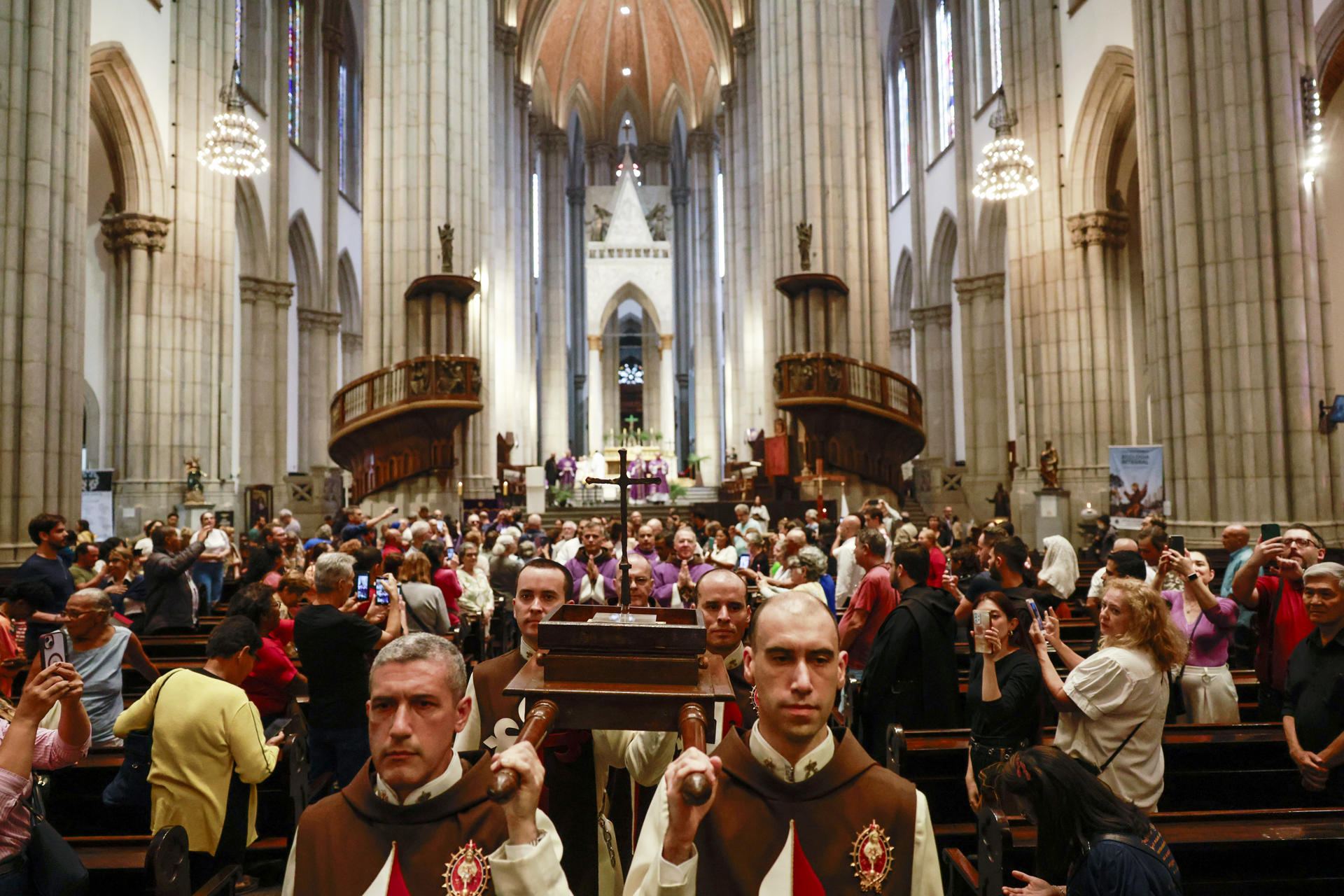 Personas transportan la cruz que se utilizó en la primera misa oficiada en Brasil, en el año 1500, durante una celebración este martes, en la Catedral Metropolitana de São Paulo (Catedral da Sé) en São Paulo (Brasil). EFE/ Sebastiao Moreira