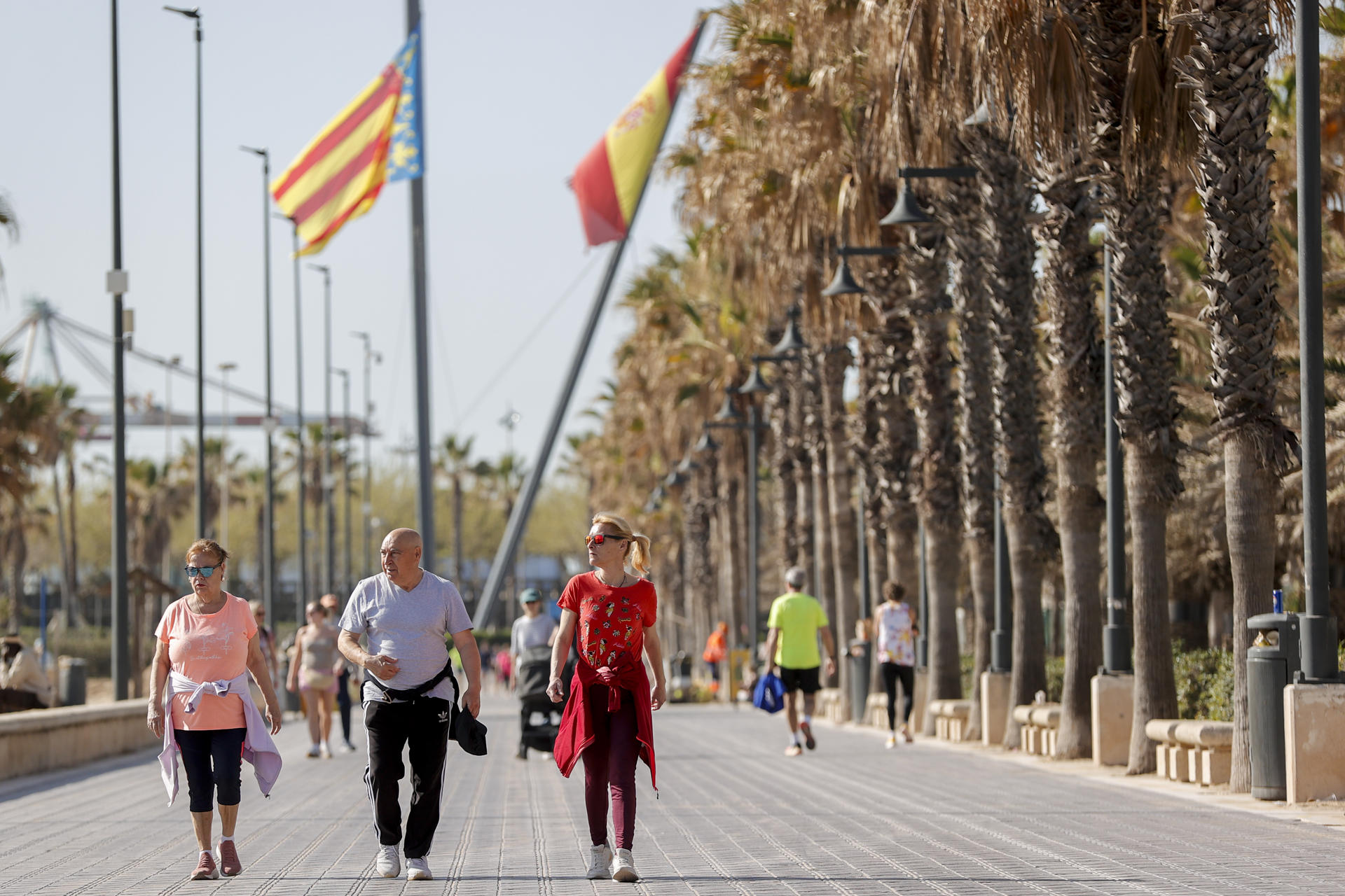 Varias personas pasean por el paseo marítimo de la playa de la Malavarrosa, en Valencia, durante este lunes. EFE/Manuel Bruque