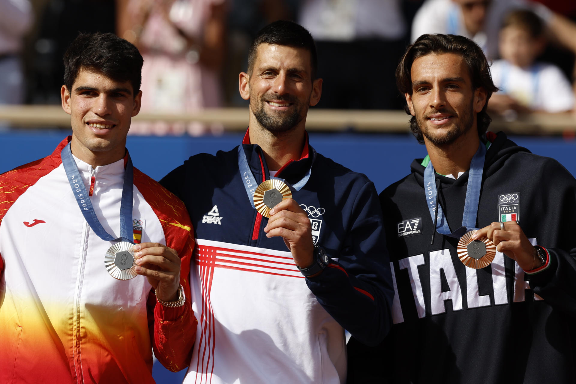El serbio Novak Djokovic (c-oro) y el español Carlos Alcaraz (i-plata) comparten el podio de los Juegos de París junto al italiano Lorenzo Musetti (d-bronce). EFE/Juanjo Martín