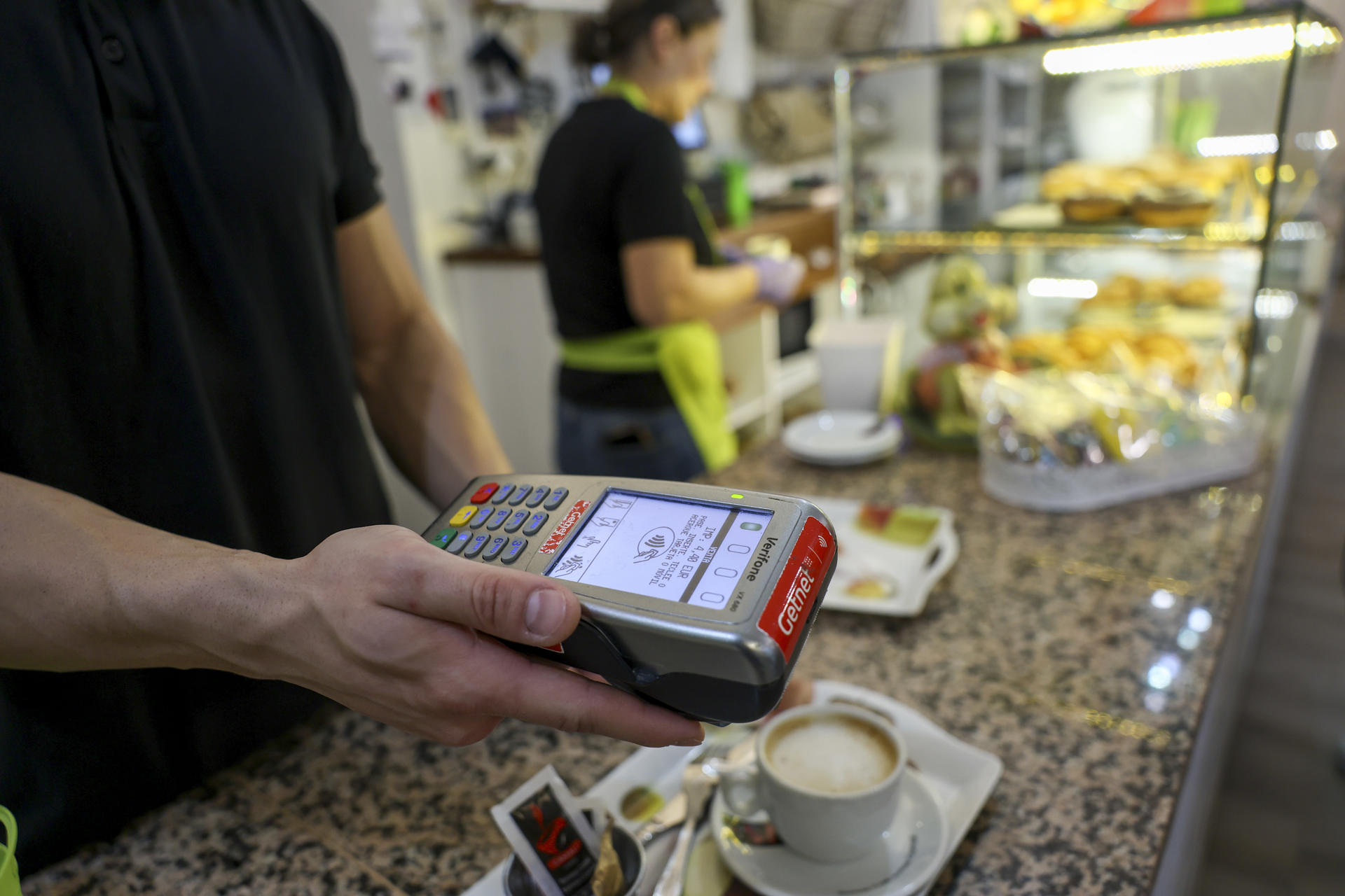 Un dependiente de hostelería cobra con un datáfono este viernes en Toledo. Los precios subieron el pasado mes de marzo en todas las comunidades autónomas, más en Islas Baleares, que presentó la tasa anual más elevada (2,9%), mientras que la Región de Murcia y Canarias tuvieron los incrementos más bajos (1,6% ambas), según los datos publicados por el Instituto Nacional de Estadística (INE). En el conjunto del país, las tasa de variación mensual del IPC general fue del 0,1%, mientras que la interanual fue del 2,3%, siete décimas inferior a la registrada el mes anterior. EFE/ Ismael Herrero