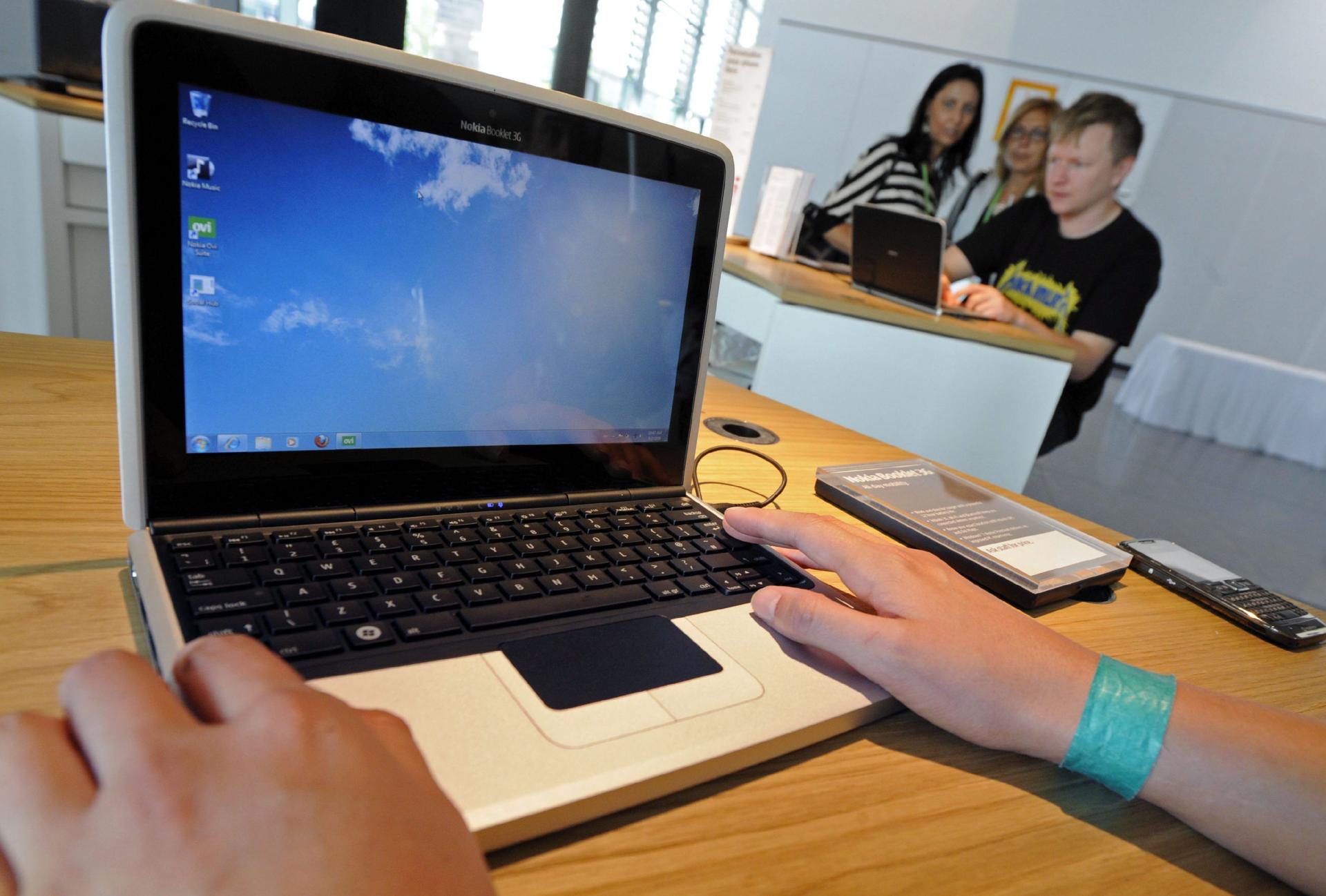 Varios visitantes examinan un ordenador portátil en una feria de electrónica, en una imagen de archivo EFE/Marijan Murat