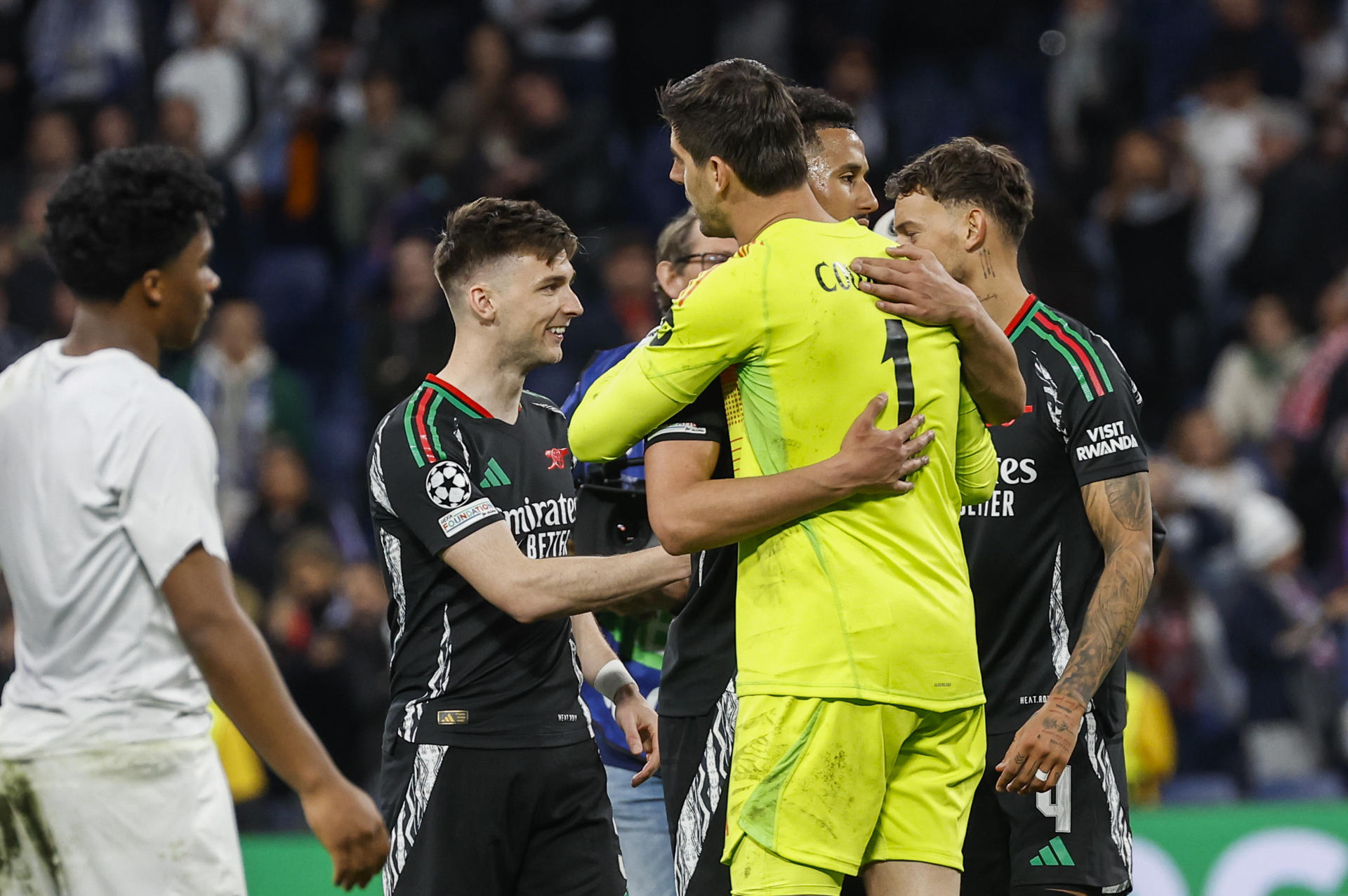 El guardameta belga del Real Madrid, Thibaut Courtois, se saluda con los jugadores del Arsenal a la finalización del encuentro de vuelta de cuartos de final de la Liga de Campeones que Real Madrid y Arsenal han disputado en el estadio Santiago Bernabéu. EFE/Chema Moya.