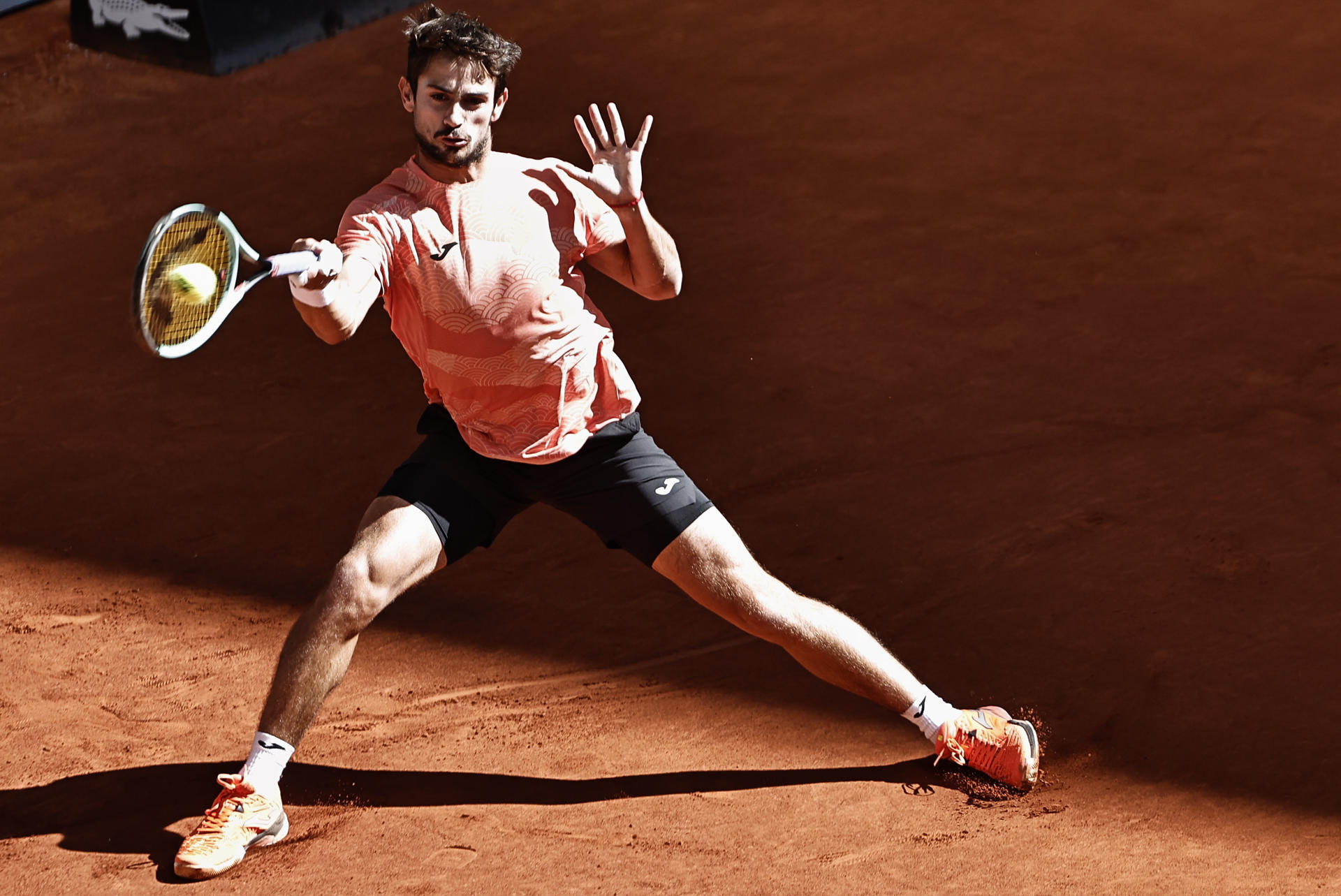 El tenista argentino Mario Navone devuelve la bola al francés Giovanni Mpetshi Perricard durante el partido de la 23ª edición del Mutua Madrid Open de tenis que se celebra este miércoles, en la Caja Mágica, en Madrid. EFE/ Sergio Pérez