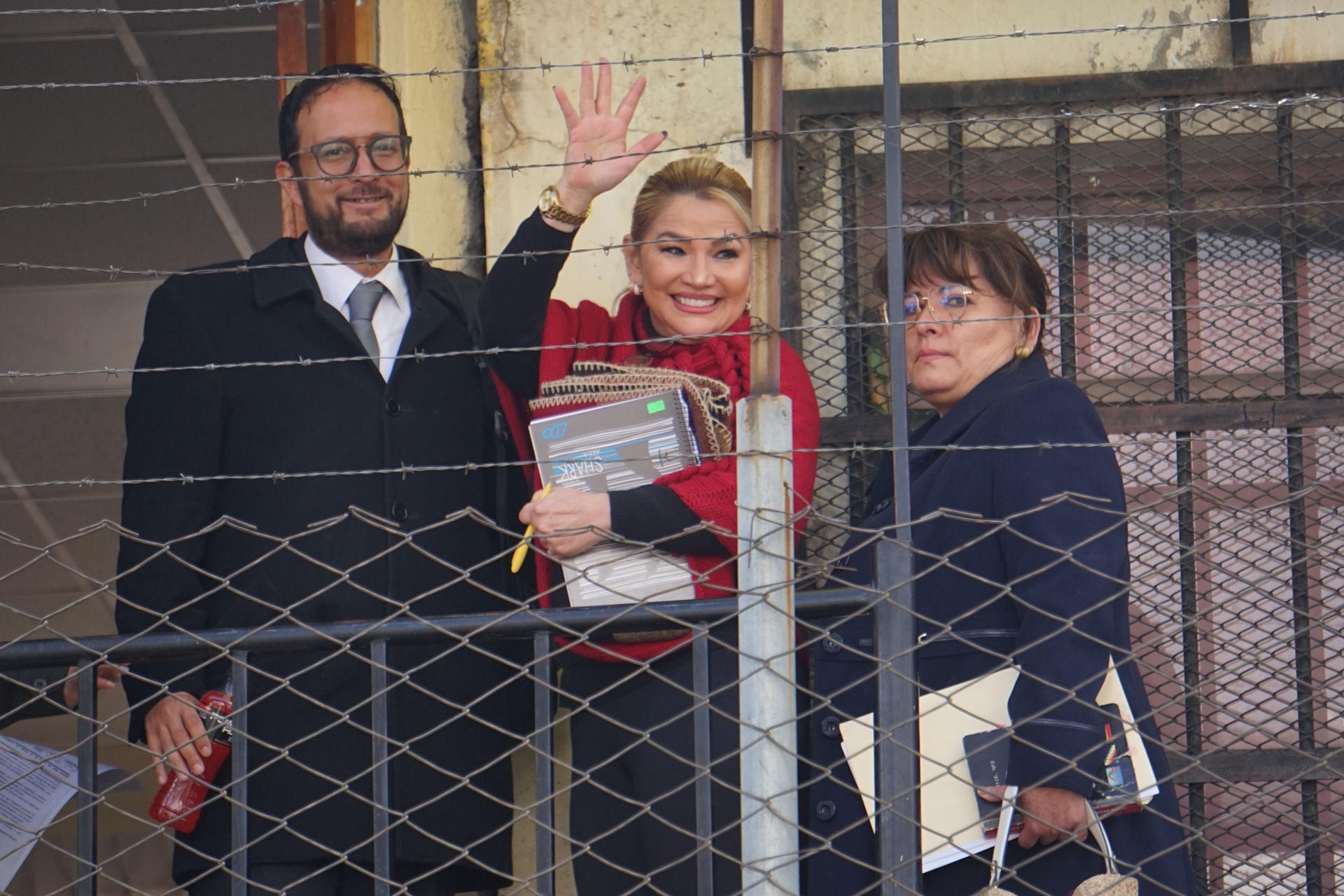 La expresidenta interina de Bolivia entre 2019 y 2020, Jeanine Áñez (c), junto a sus abogados Luis Guillén (i) y Norka Cuéllar, al saludar este viernes, 4 de abril, en el Centro de Orientación Femenina de Miraflores, en La Paz (Bolivia). EFE/Stringer