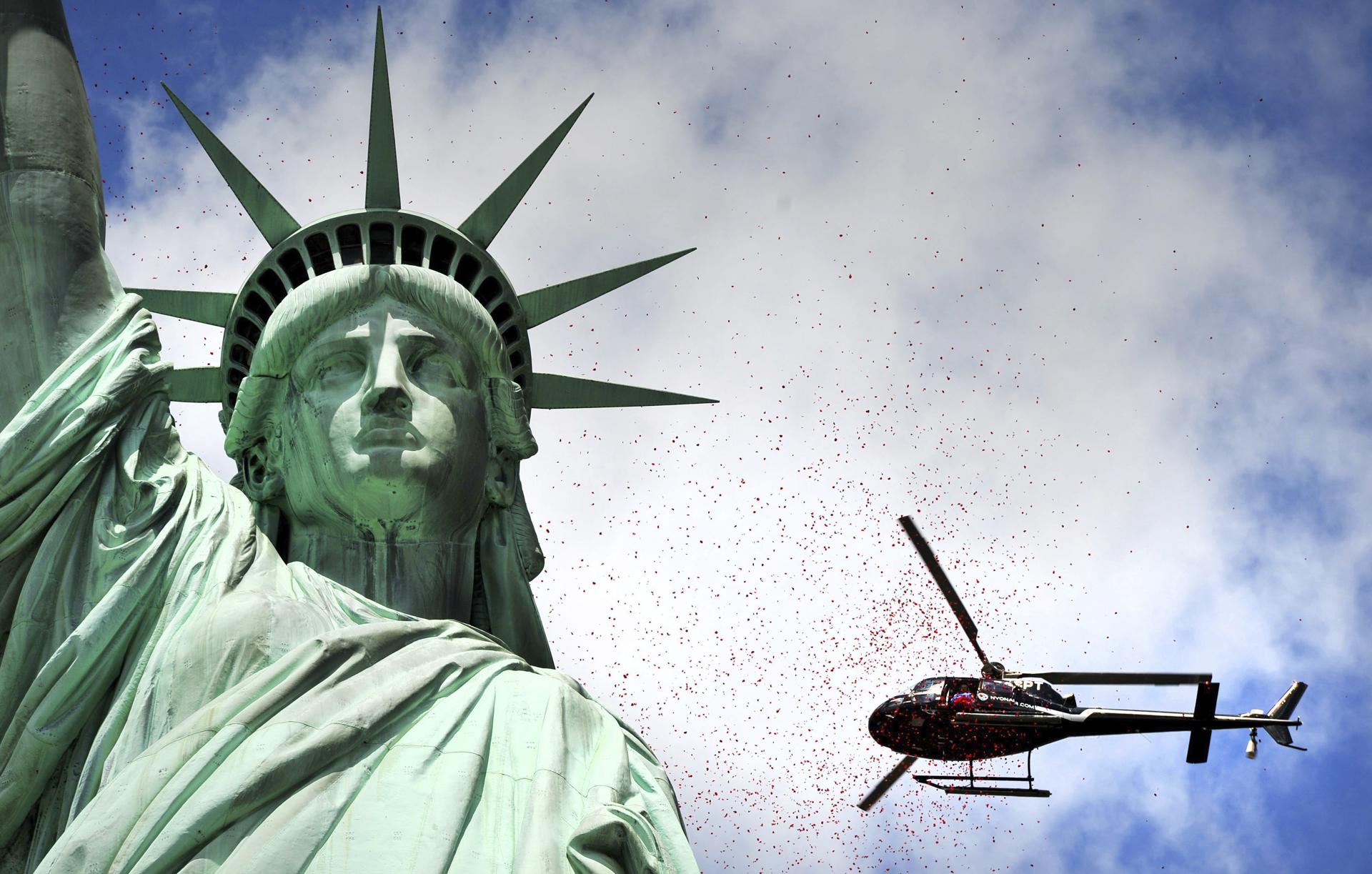 Fotografía de archivo en donde se ve un helicóptero que pasa junto a la Estatua de la Libertad en la ciudad de Nueva York, Estados Unidos. EFE/Justin Lane
