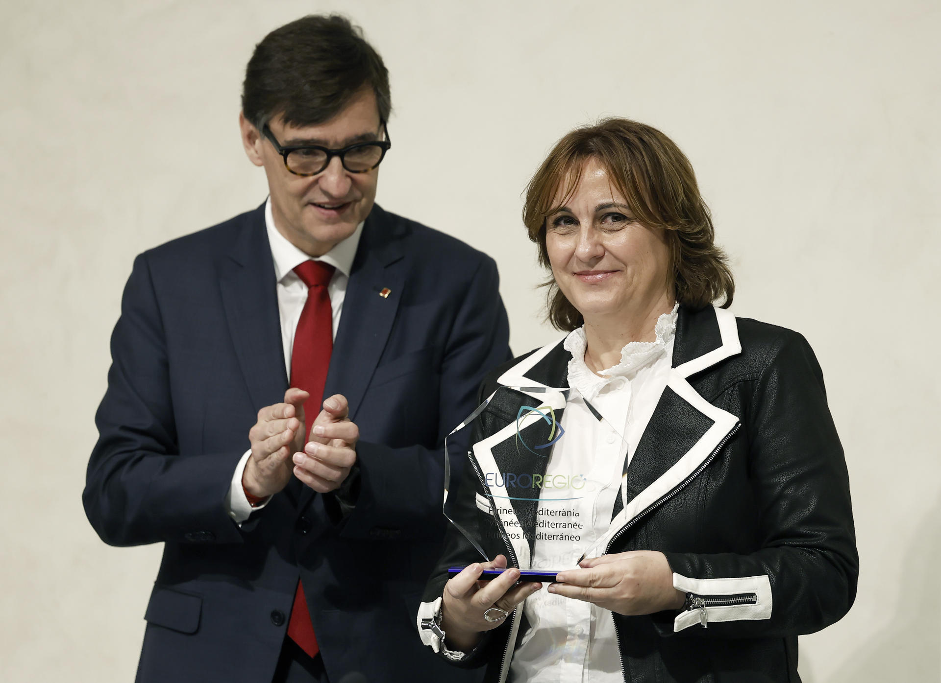 El presidente catalán, Salvador Illa (i),  y la consellera de la Presidencia balear, Antònia Maria Estarellas (d), durante el acto de traspaso de la presidencia de la Eurorregión Pirineos Mediterráneo, que durante los próximos dos años asumirá el ejecutivo balear desde donde Illa ha llamado este miércoles a defender el proyecto europeo "por encima de ideologías y creencias" y se ha mostrado convencido de que la Unión Europea logrará "fortalecerse" en el que ha definido como uno de sus momentos "más trascendentales".EFE/ Andreu Dalmau