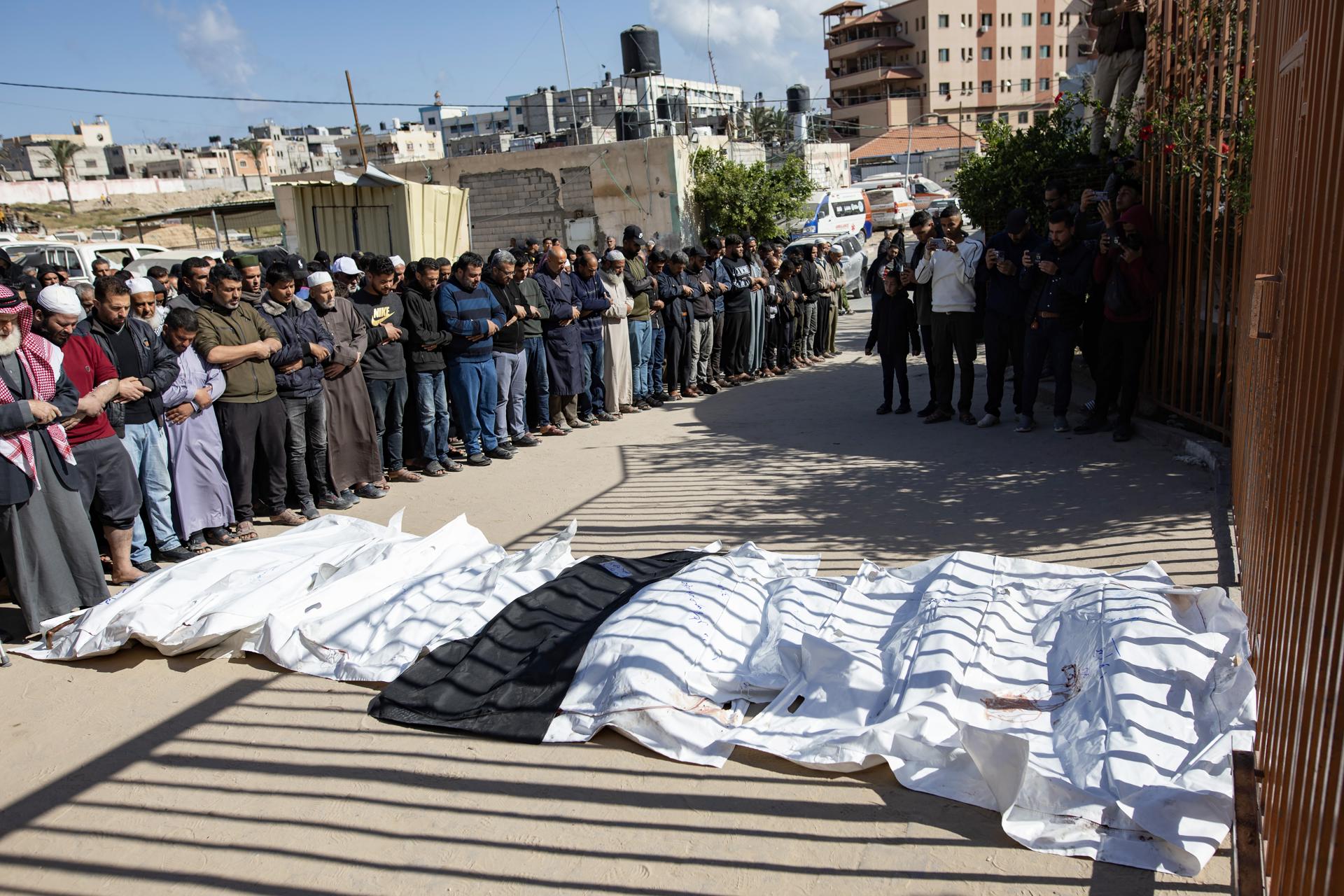 Familiares de las víctimas de la familia palestina Al Farra rezan cerca de sus cuerpos cubiertos en el Hospital Nasser en Jan Yunis, al sur de la Franja de Gaza, el 11 de abril de 2025. EFE/EPA/HAITHAM IMAD