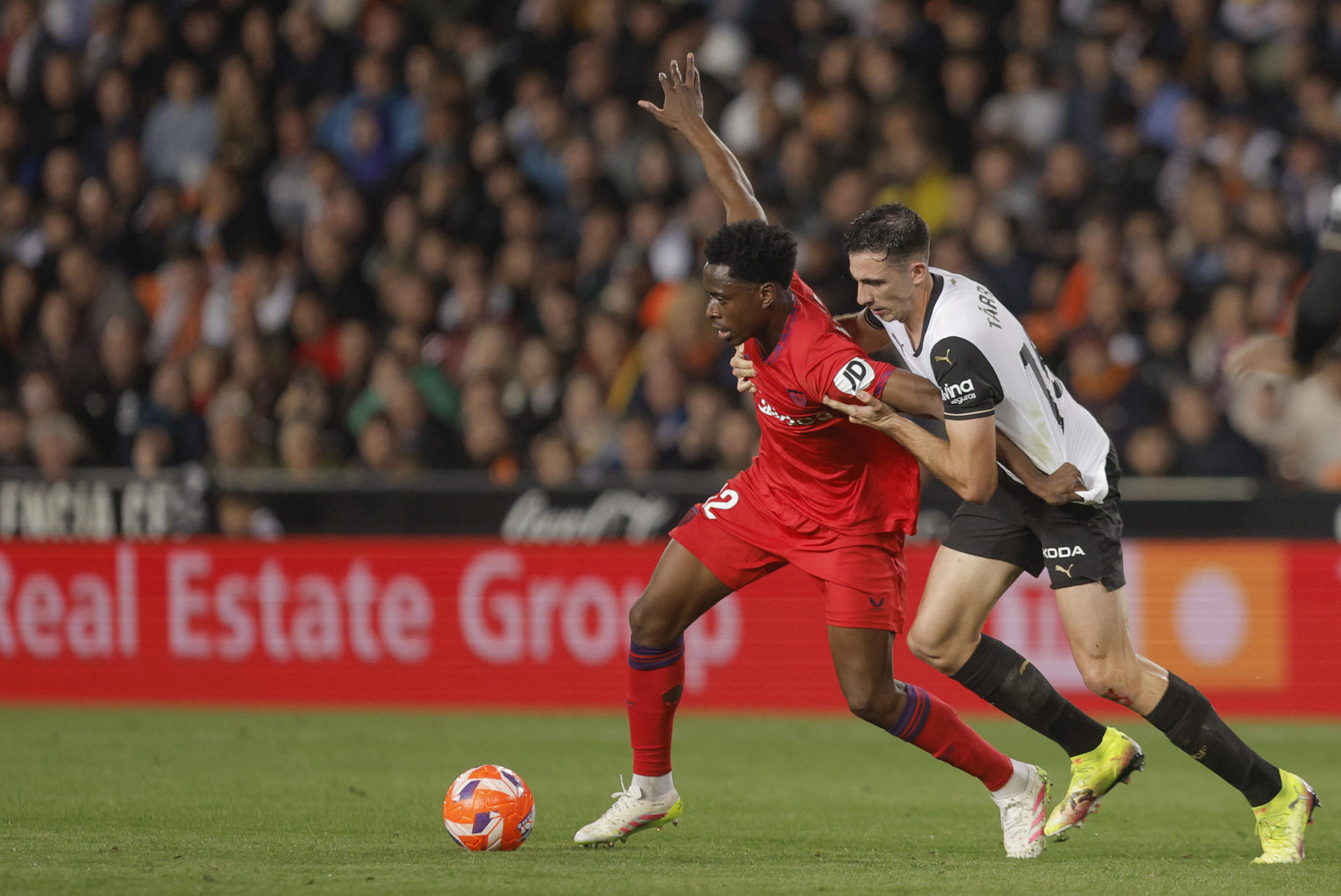El defensa del Valencia César Tárrega (d) disputa el balón con el centrocampista belga del Sevilla Albert Sambi durante el partido de Liga disputado este viernes en el estadio de Mestalla. EFE/Kai Forsterling