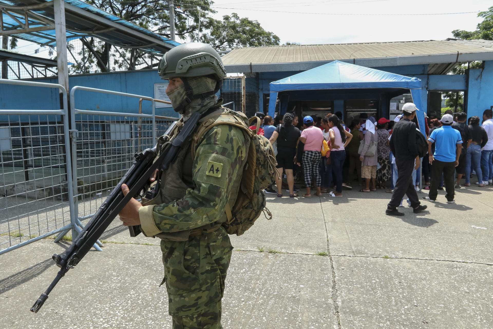 Fotografía de militares con familiares de reos que esperan información en los exteriores de la Penitenciaría del Litoral, en Guayaquil (Ecuador). EFE/ Jhonatan Miranda