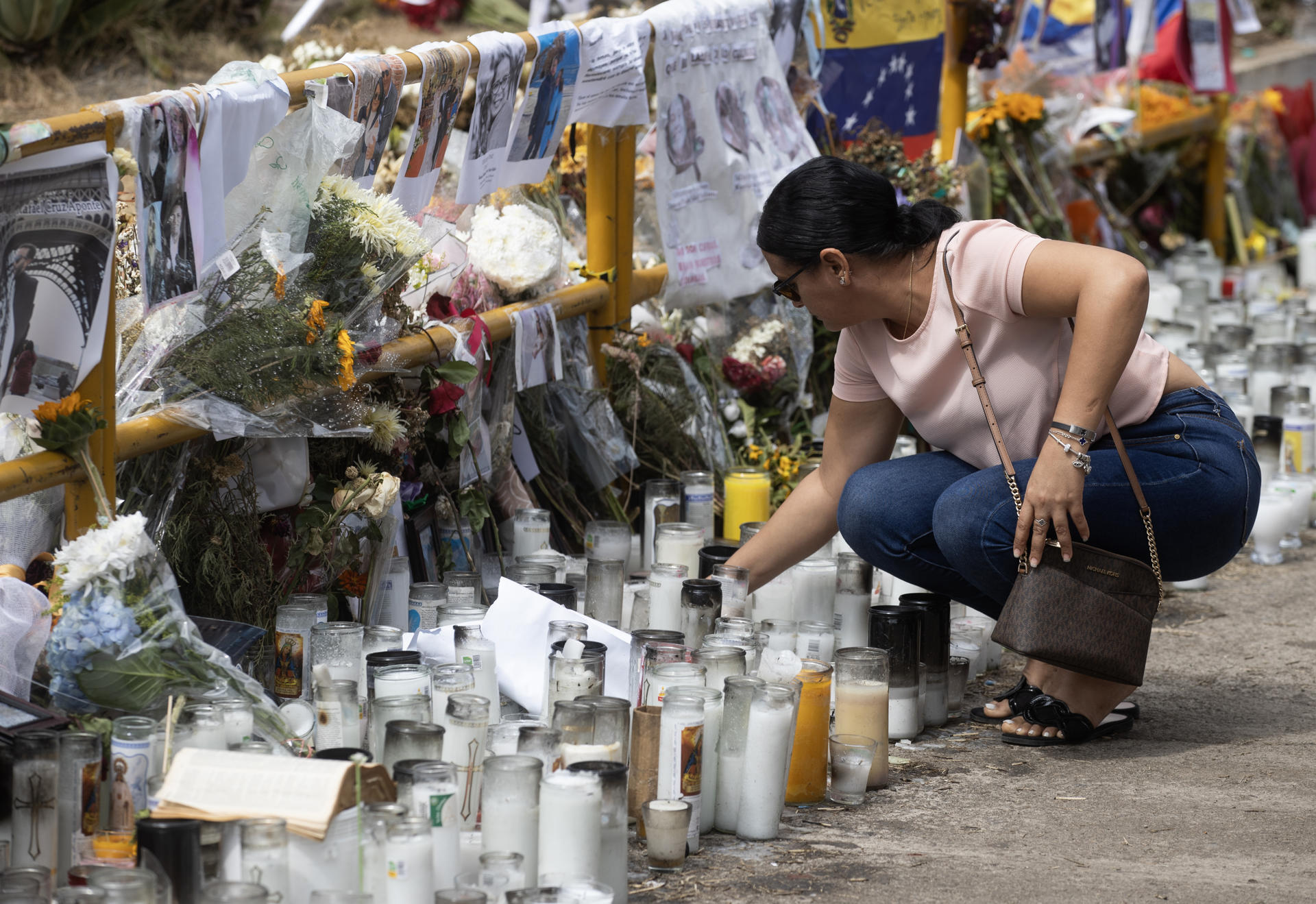Foto de archivo que muestra a una persona colocando una vela en medio de las ofrendas puestas a la entrada de la discoteca Jet Set en Santo Domingo (República Dominicana). EFE/Orlando Barría