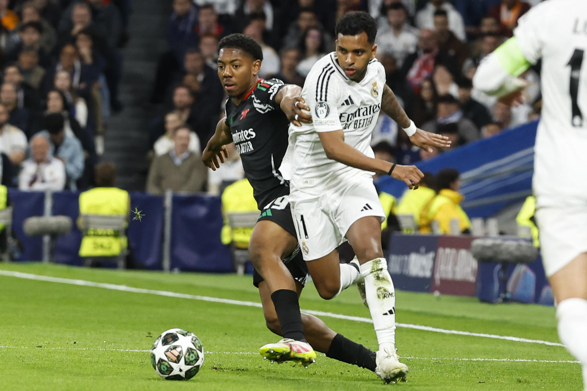 El delantero del Real Madrid Rodrygo Goes (d) lucha con Myles Lewis-Skelly, del Arsenal, durante el partido de vuelta de cuartos de final de la Liga de Campeones que Real Madrid y Arsenal jugaron en el estadio Santiago Bernabéu. EFE/Chema Moya