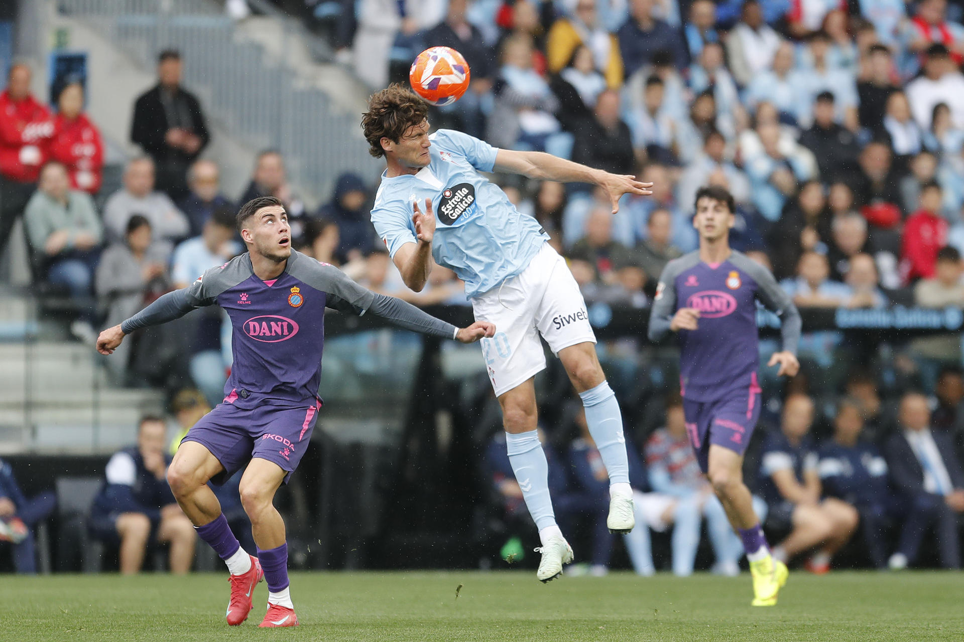 El defensa del Celta Marcos Alonso (c) disputa un balón con el delantero del Espanyol Roberto Fernández (i) durante el encuentro de LaLiga entre Celta de Vigo y RCD Espanyol, este sábado en el estadio de Balaídos, en Vigo. EFE/ Salvador Sas