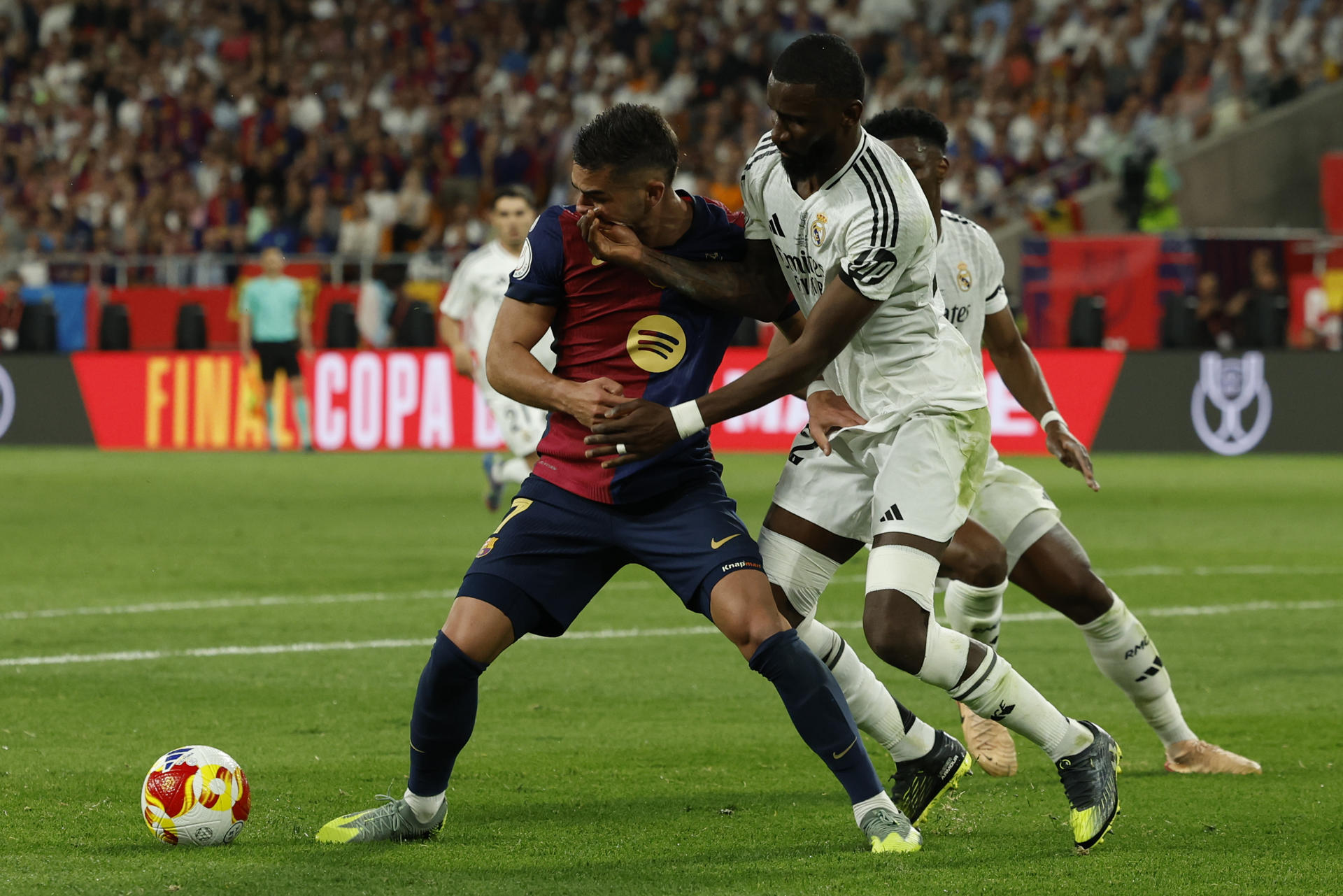 El defensa alemán del Real Madrid, Antonio Rudiger, pugna por el balón con el delantero del Barcelona Ferrán Torres (i), durante la final de la Copa del Rey que disputaron el sábado en el estadio de La Cartuja, en Sevilla. EFE / Julio Muñoz.