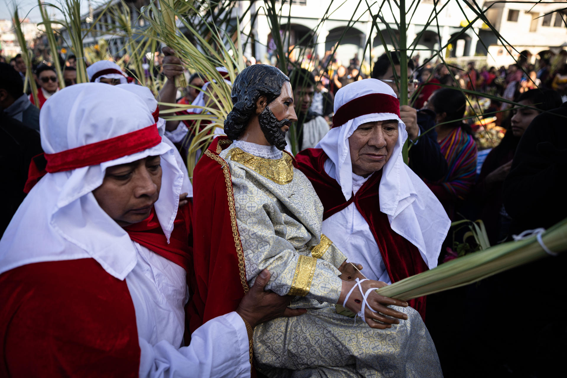 Dos fieles católicos cargan la imagen de Jesús durante la procesión de Las Palmas este domingo en el poblado indígena de San Pedro Sacatepéquez en el oeste de Guatemala. EFE/David Toro