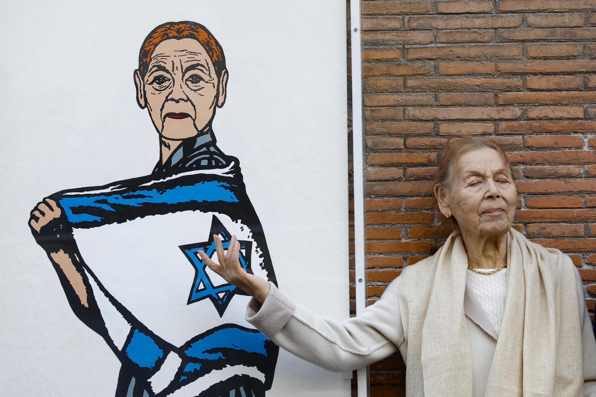 La escritora de origen húngaro y superviviente del Holocausto Edith Bruck posa para un retrato junto a un mural del artista italiano AleXsandro Palombo que la representa, en el barrio judío de Roma, Italia, 07 de abril de 2025. (Italy, Rome) EFE/EPA/FABIO FRUSTACI