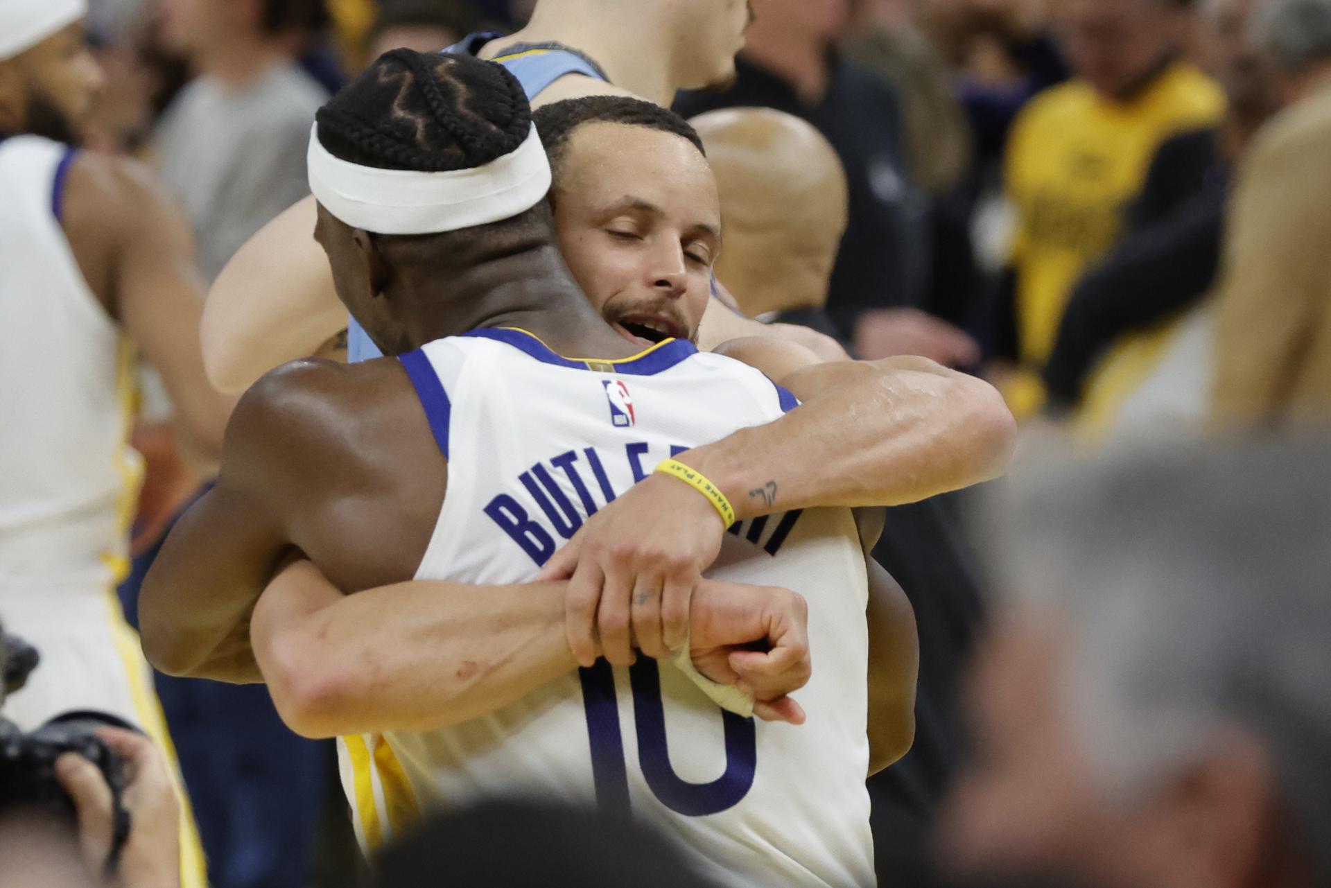 El escolta de los Golden State Warriors, Stephen Curry, abraza a su compañero de equipo Jimmy Butler tras derrotar a los Memphis Grizzlies en la NBA en San Francisco, California, EE. UU. EFE/EPA/JOHN G. MABANGLO