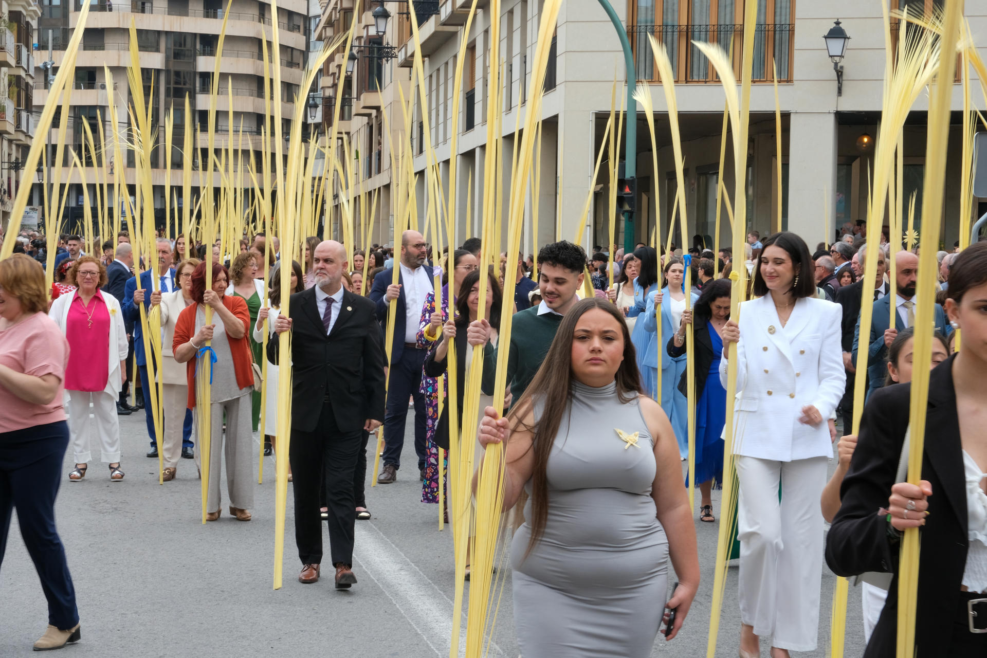 La procesión del Domingo de Ramos recorre las calles de Elche, este domingo, con miles de personas portando palmas blancas artesanales, símbolo distintivo de la ciudad. EFE/ Pablo Miranzo