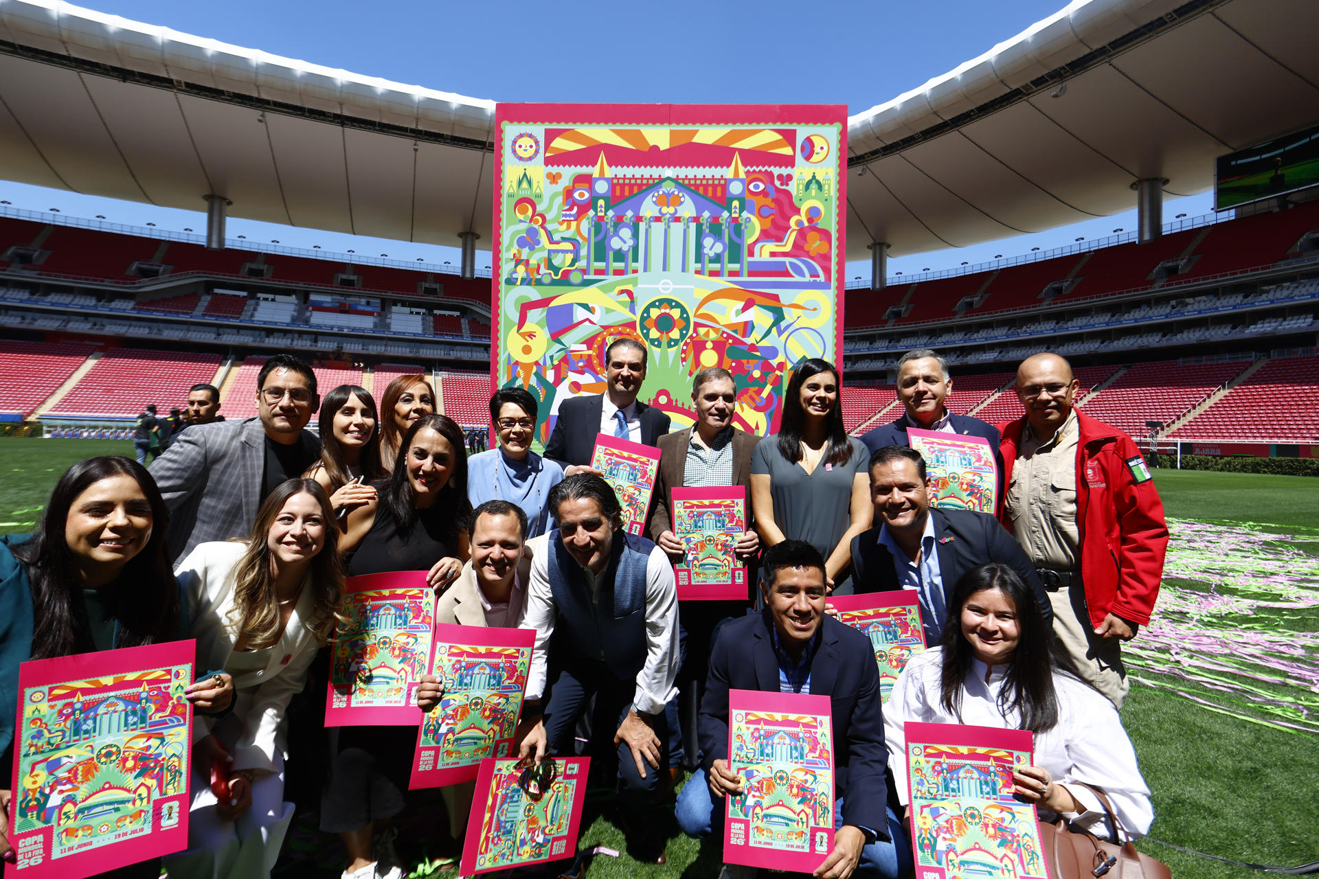 Personas posan junto a la imagen oficial para el Mundial de Fútbol 2026 este miércoles, en el estadio Guadalajara (México). EFE/ Francisco Guasco