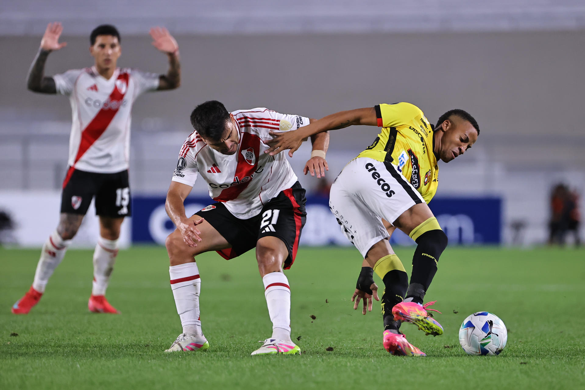 Marcos Acuña (c) de River disputa el balón con Byron Castillo de Barcelona en un partido de la fase de grupos de la Copa Libertadores. EFE/ Juan Ignacio Roncoroni