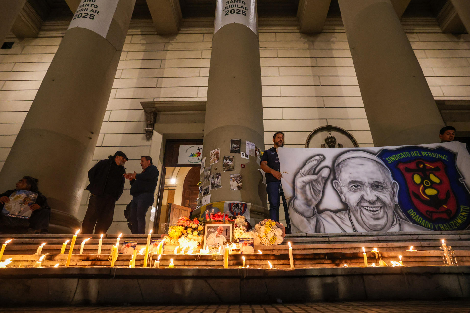 Personas encienden velas durante un homenaje al papa Francisco este lunes, frente a la Catedral Metropolitana de Buenos Aires (Argentina). EFE/ Juan Ignacio Roncoroni