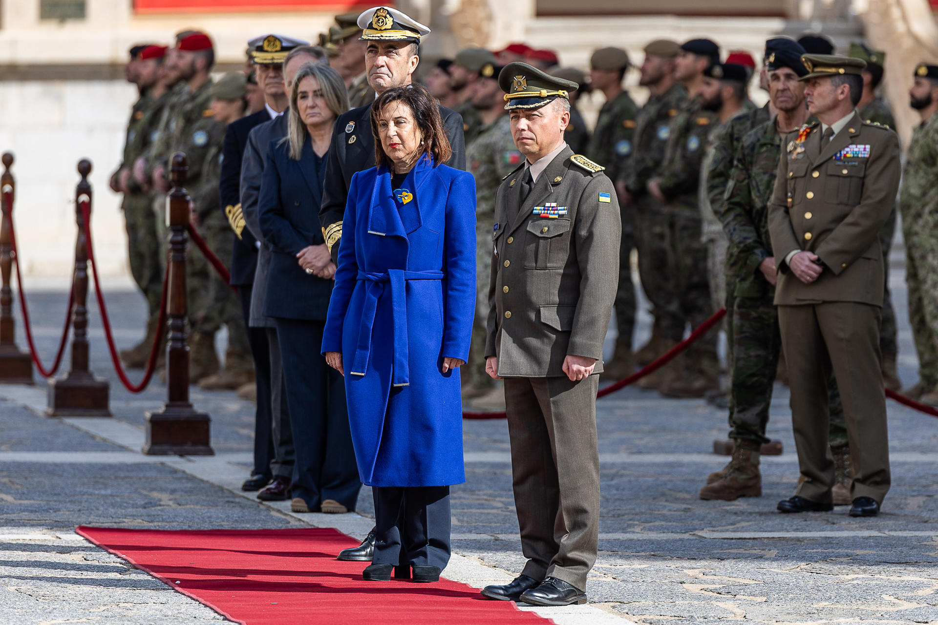 La ministra de Defensa, Margarita Robles (c), acompañada de un oficial ucraniano, preside el acto de homenaje a los civiles y militares caídos en la guerra de Ucrania en la Academia de Infantería de Toledo, en febrero último. EFE/Ismael Herrero