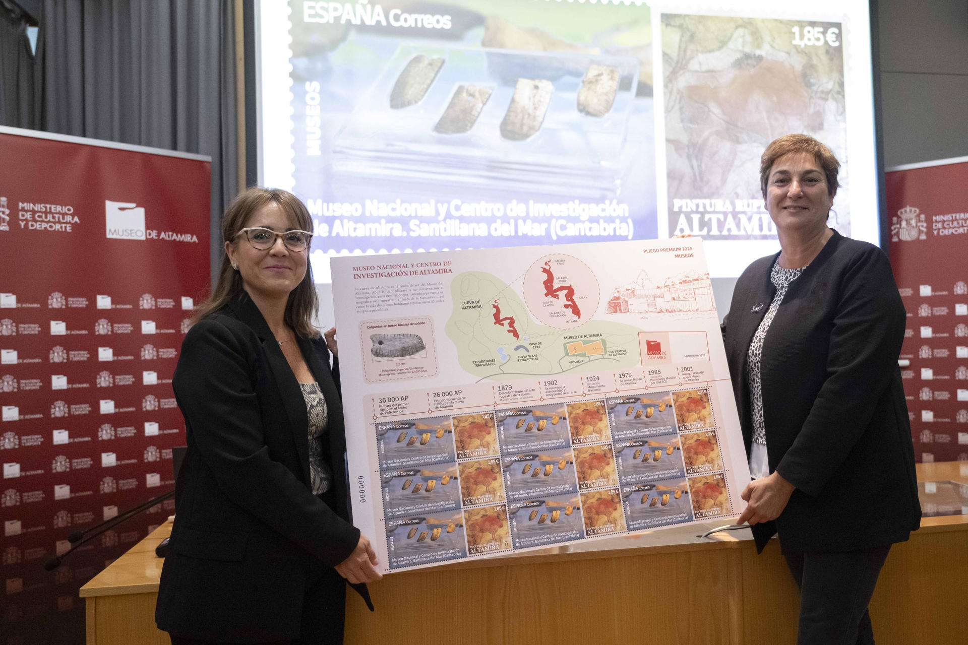 La directora del Museo Nacional y Centro de Investigación de Altamira, Pilar Fatás (d), y la directora de Filatelia y Relaciones Institucionales de Correos, Nuria Lera Hervás (i), durante la presentación del sello que Correos ha dedicado este año al Museo de Altamira, este viernes en la localidad cántabra de Santillana del Mar. EFE/ Pedro Puente Hoyos