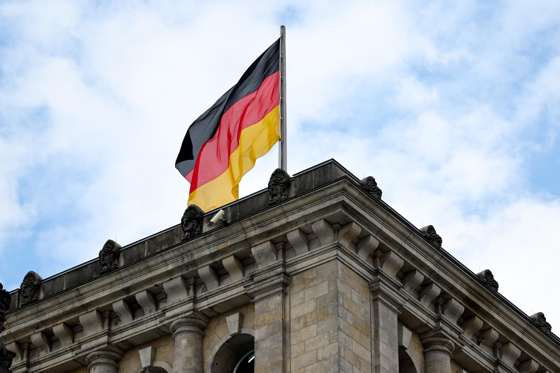 Una bandera alemana ondea al viento en lo alto del Bundestag, el parlamento alemán, en Berlín, Alemania